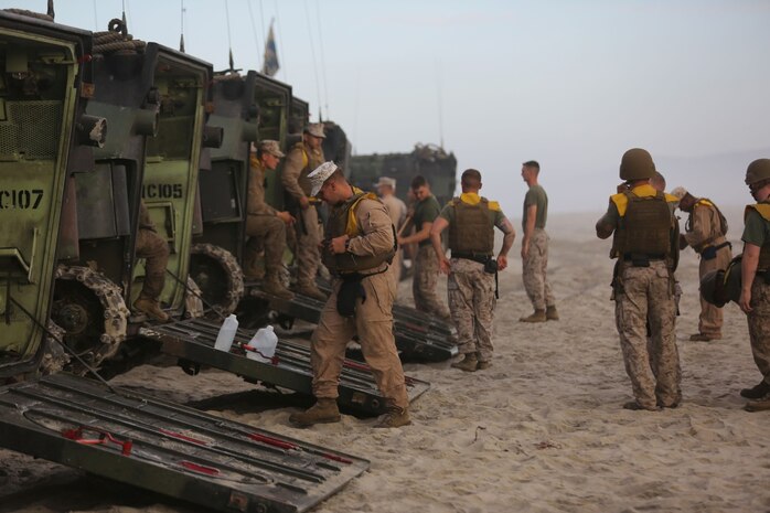 Marines with Charlie Company, 3rd Assault Amphibian Battalion, prepare to board an Amphibious Assault Vehicle during a surf qualification here, Sept. 6, 2013. The training ensured the Marines know how to properly evacuate their AAV and swim back to shore in case of an emergency. The battalion conducts the surf qualification annually. The swim to shore presents the Marines with many challenges, including the confidence to jump into the cold water while facing the waves rushing over them.