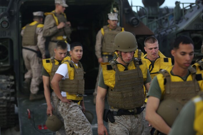 Marines with Charlie Company, 3rd Assault Amphibian Battalion, prepare to board an Amphibious Assault Vehicle during a surf qualification here, Sept. 6, 2013. The training ensured the Marines know how to properly evacuate their AAV and swim back to shore in case of an emergency. The battalion conducts the surf qualification annually. The swim to shore presents the Marines with many challenges, including the confidence to jump into the cold water while facing the waves rushing over them.