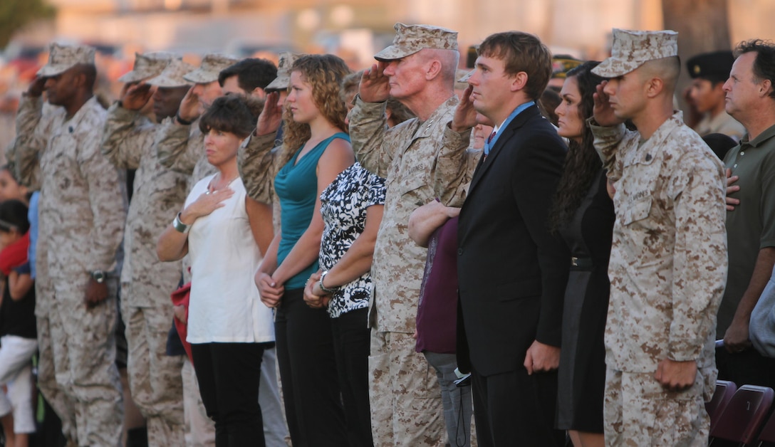 Dakota Meyer, the youngest living Medal of Honor recipiant, stands at attention while Marines, Sailors and first responders salute the colors as taps played aboard Marine Corps Air Station Miramar, Calif., during a 9/11 Warrior Recognition Evening Colors Ceremony, Sept. 11. The Marines of the 3rd Marine Aircraft Wing and MCAS Miramar observed Patriot Day by honoring the sacrifice of the first responders and service members who gave their lives, as well as recognizing Lt. Col. Christopher K. Raible and Sgt. Bradley W. Atwell for their actions during the attack on Camp Bastion, Sept. 14, 2012.