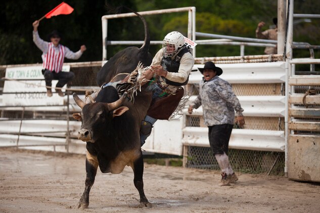A contestant hangs on as his bull bucks him around during the inaugural Surf & Turf Buck & Bull Event & Concert at the New Town & Country Stables in Waimanalo, Hawaii, Sept. 7, 2013. (U.S. Marine Corps photo by Lance Cpl. Matthew Bragg)