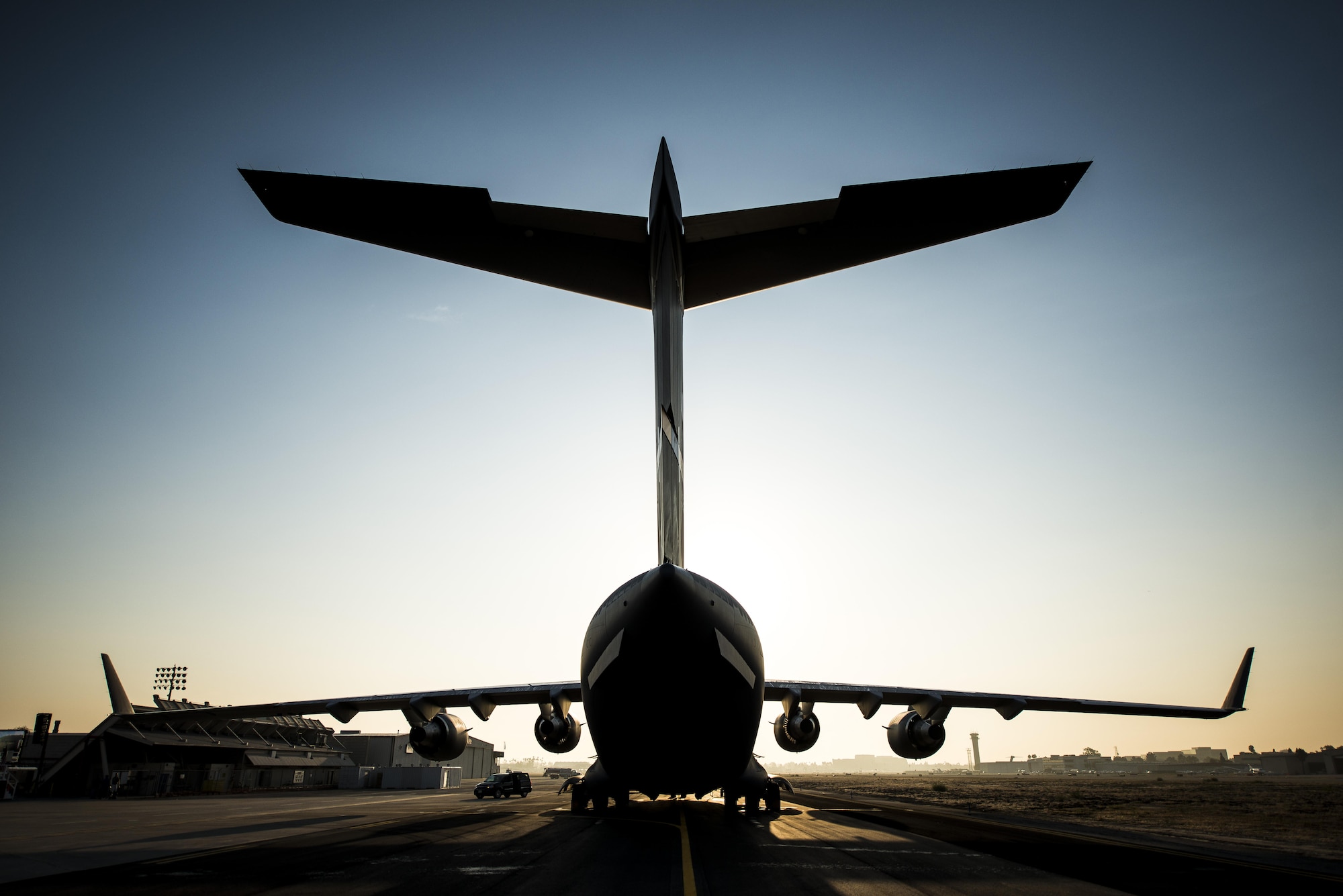 The sun rises above the final U.S. Air Force C-17 Globemaster III, P-223, as crew members arrive at the Boeing plant Sept. 12, 2013, at Long Beach, Calif. The C-17 was flown from California to Joint Base Charleston, S.C.