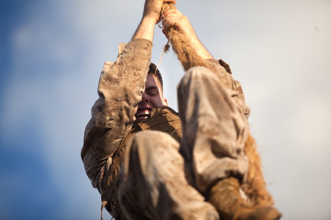 Cpl. Benjamin Cavanaugh, a Covington, Wash. Native and student in the Marine Corps Martial Arts Instructor Course, climbs the rope of the obstacle course for a third time before moving on to the assault bayonet course at Boondocker training area, Marine Corps Base Hawaii, Sept. 6, 2013. The assault bayonet course teaches Marines how to fight with a bayonet in a close-quarters environment.  Marine squad advisors with the instructor course hid throughout the path, attacking the students, who must then fend them off with counter strikes. (U.S. Marine Corps photo by Cpl. Matthew Callahan)