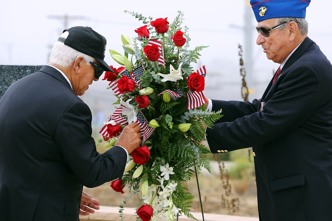 Bob Licker, right, holds the wreath for Chosin Few veterans that are placing American flags during the 63rd Anniversary of the Landing on Inchon Memorial Ceremony held at the Chosin Few Monument adjacent to the Pacific Views Event Center here Sept. 13. The ceremony is also a time to commemorate those who gave their life during the conflict. Licker was a once the National President of the Chosin Few Chapter.