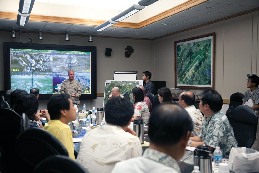 Lt. Col. Sean P. Patak, center left, speaks to a delegation of the Liberal Democratic Party of Japan Sept. 9 at Marine Corps Air Station Futenma. The delegation visited the air station to learn more about the air station’s capabilities and the MV-22B Osprey. Patak is the executive officer of MCAS Futenma. 