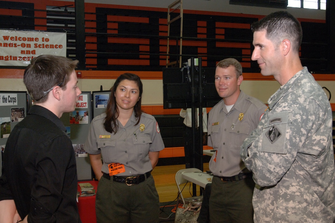 Maj. Brad Morgan (Right), U.S. Army Corps of Engineers Nashville District deputy commander, and Old Hickory Lake Park Rangers Charlie Leath and Amy Redmond talk with a student participating in Hands-On Science and Engineering Day at Stratford STEM Magnet High School in Nashville, Tenn., Sept. 12, 2013. The students moved from station to station asking questions of community partners about careers in science and technology.
