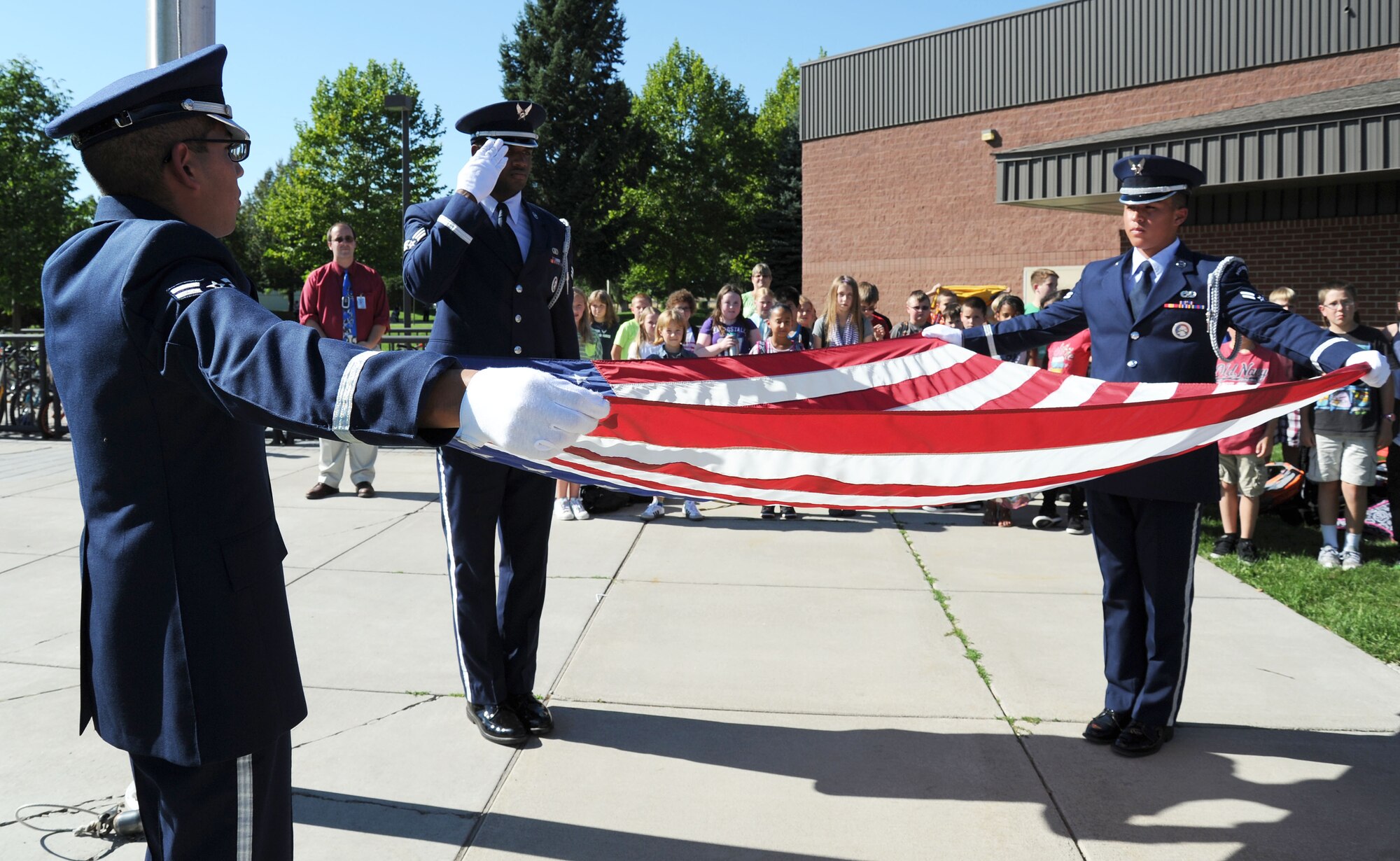 Fairchild Air Force Base honor guard members fold an American flag during a Retreat ceremony held at the Michael Anderson Elementary School at Fairchild Air Force Base, Wash., Sept. 11, 2013. The school organized a coloring contest and retreat ceremony to pass on the memory of those individuals who served and saved on that day. (U.S. Air Force photo by Airman 1st Class Janelle Patiño/Released)