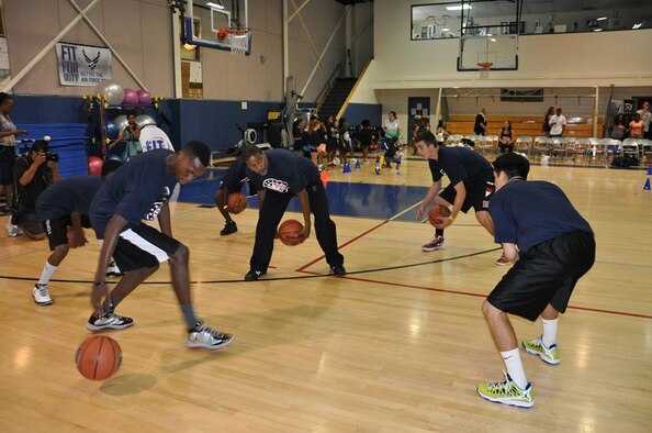 National Basketball Association legend, Norm Nixon, guides military dependents through a basketball drill using fundemental techniques at March Air Reserve Base, Calif., during the NBA Cares Hoops for Troops basketball clinic Sunday, Sept. 8, 2013. The NBA Cares program sponsored the event in conjunction with the Healthy Base Initiative kickoff. (U.S. Air Force photo/Master Sgt. Linda Welz)