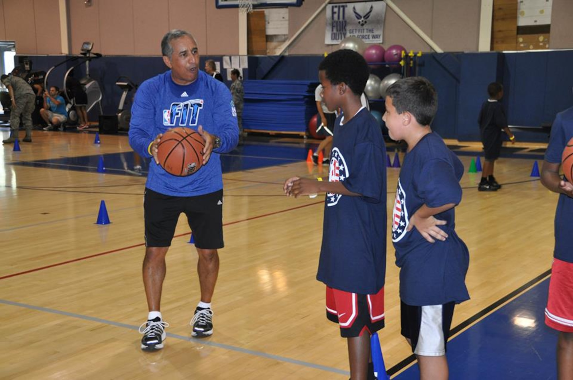 National Basketball Association clinician, Frank Lopez, instructs military dependents on proper ball-handling techniques at March Air Reserve Base, Calif., during the NBA Cares Hoops for Troops basketball clinic Sunday, Sept. 8, 2013. The NBA Cares program sponsored the event in conjunction with the Healthy Base Initiative kickoff. (U.S. Air Force photo/Master Sgt. Linda Welz)