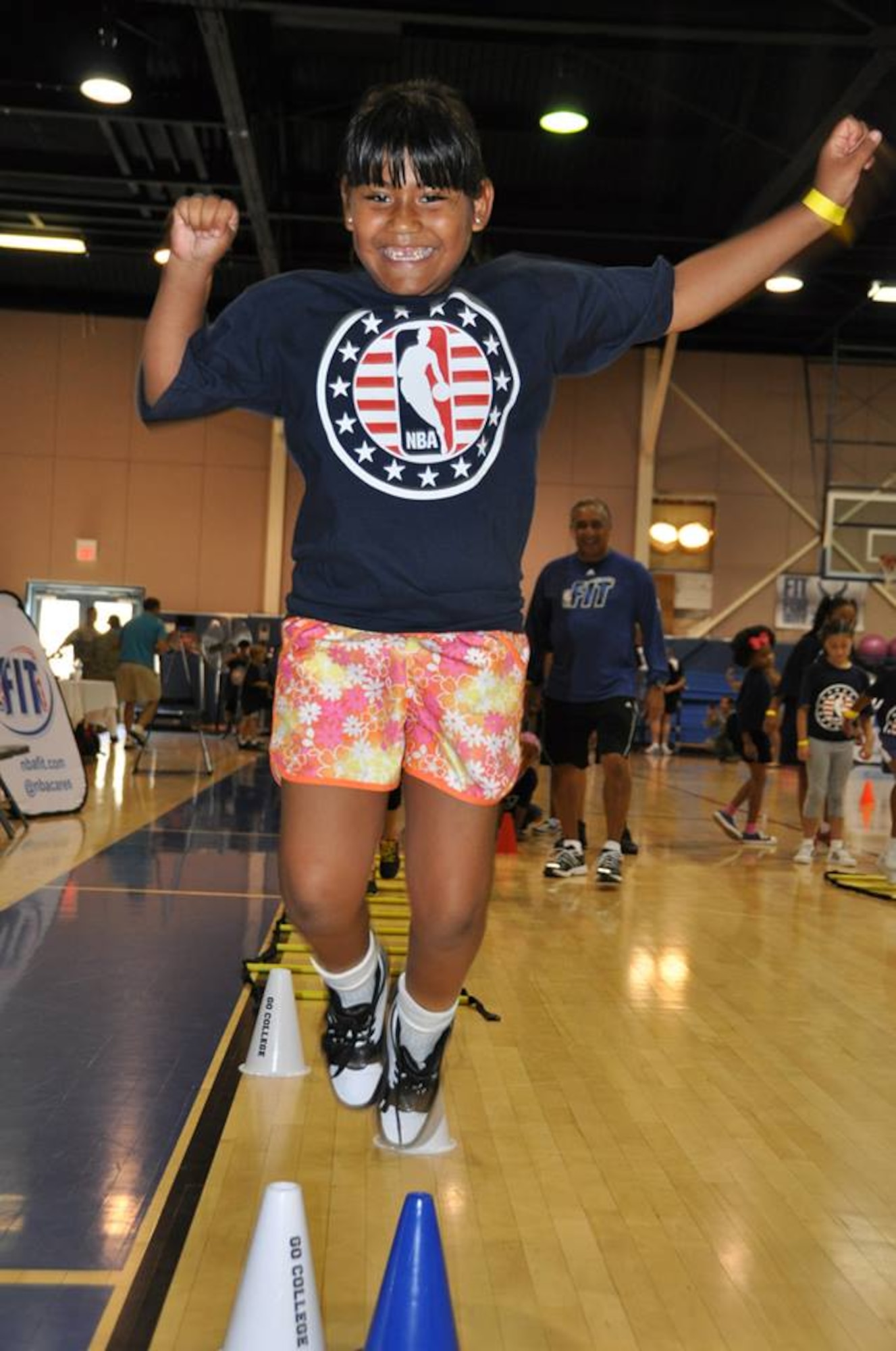 A military dependent jumps over the cones at the end of an exercise at March Air Reserve Base, Calif., during the NBA Cares Hoops for Troops basketball clinic Sunday, Sept. 8, 2013. The NBA Cares program sponsored the event in conjunction with the Healthy Base Initiative kickoff. (U.S. Air Force photo/Master Sgt. Linda Welz)