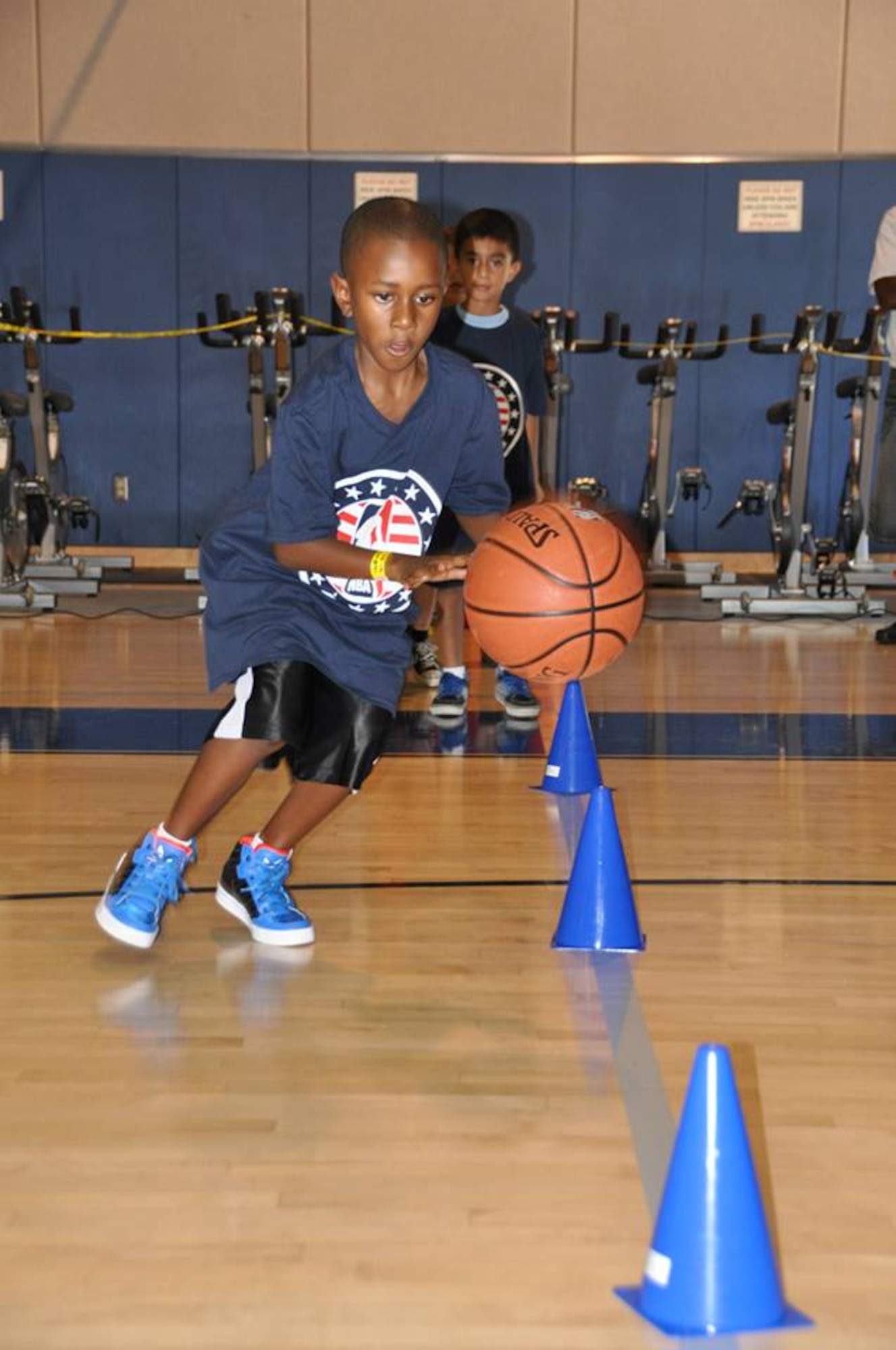 A military dependent dribbles the ball at March Air Reserve Base, Calif., during the NBA Cares Hoops for Troops basketball clinic Sunday, Sept. 8, 2013. The NBA Cares program sponsored the event in conjunction with the Healthy Base Initiative kickoff. (U.S. Air Force photo/Master Sgt. Linda Welz)