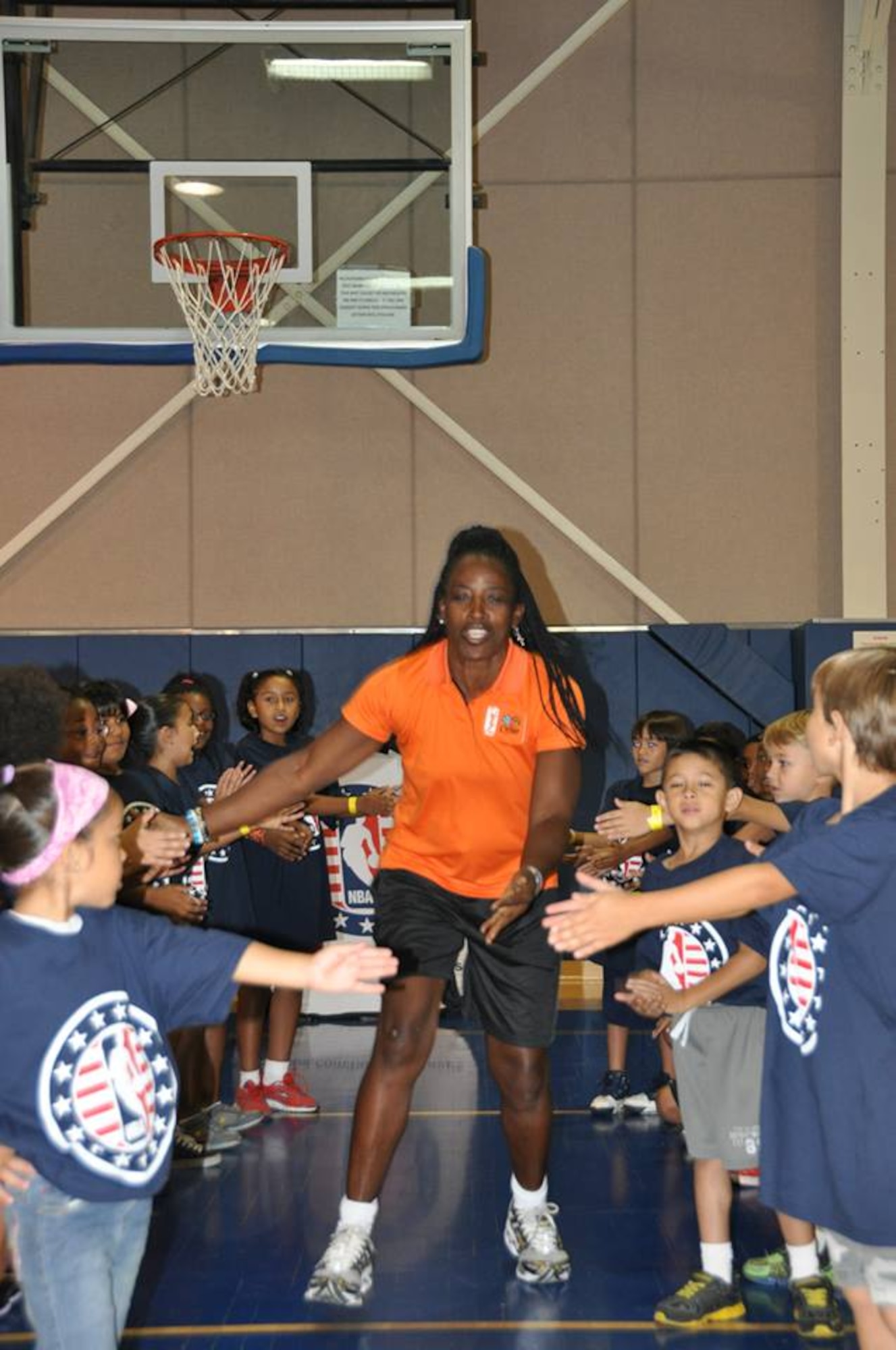 Ruthie Bolton, former Women’s National Basketball Association star and two-time Olympic gold medalist, is greeted by military children at March Air Reserve Base, Calif., during the NBA Cares Hoops for Troops basketball clinic Sunday, Sept. 8, 2013. The NBA Cares program sponsored the event in conjunction with the Healthy Base Initiative kickoff. (U.S. Air Force photo/Master Sgt. Linda Welz)