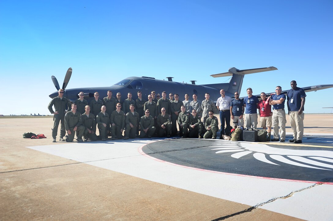 Members of the 318th Special Operations Squadron pose for a group photo after the arrival of a U-28A aircraft Aug. 30, 2013 at Cannon Air Force Base, N.M. The Intelligence, Surveillance and Reconnaissance mission-based aircraft will make a permanent home with the 318 SOS, which specializes in delivering rapid special operations airlift support across the globe. (U.S. Air Force photo/Senior Airman Xavier Lockley) 