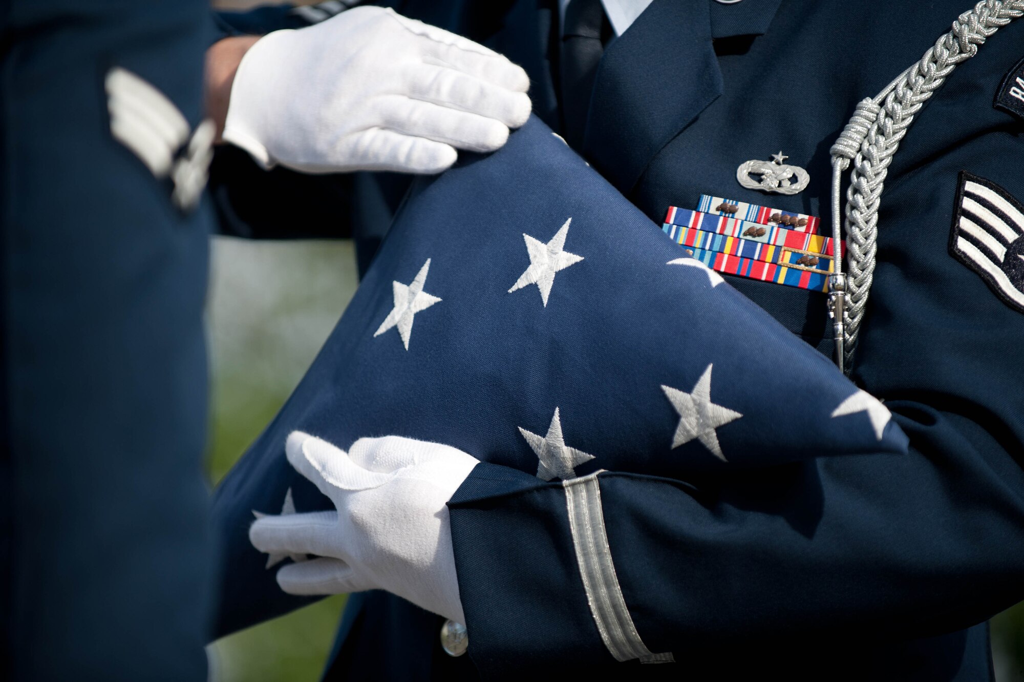 Staff Sgt. Bobby Pantfoader, 28th Force Support Squadron base Honor Guardsman, performs a flag folding demonstration during the 9/11 Remembrance Retreat ceremony held in front of the 28th Bomb Wing Headquarters at Ellsworth Air Force Base, S.D., Sept. 11, 2013. The ceremony was held to pay homage to those lost in wartime and during the tragic events that occurred on Sept. 11, 2001. (U.S. Air Force photo by Airman 1st Class Zachary Hada/Released)