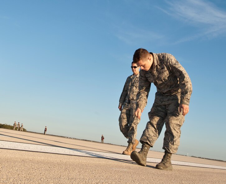 U.S. Air Force Airman 1st Class Trevor Newirth, 7th Logistics Readiness Squadron, picks up debris while participating in a Foreign Object Debris (FOD) walk Sept. 9, 2013, at Dyess Air Force Base, Texas. Every Airman at Dyess AFB has a responsibility to ensure FOD is minimized. The Wing FOD management office hosts monthly FOD walks to minimize possible damage to aircraft from debris. On Aug. 29, Dyess reached a new pinnacle of FOD prevention; 1,500 days without a chargeable FOD incident. (U.S. Air Force photo by Staff Sgt. Richard Ebensberger/Released)