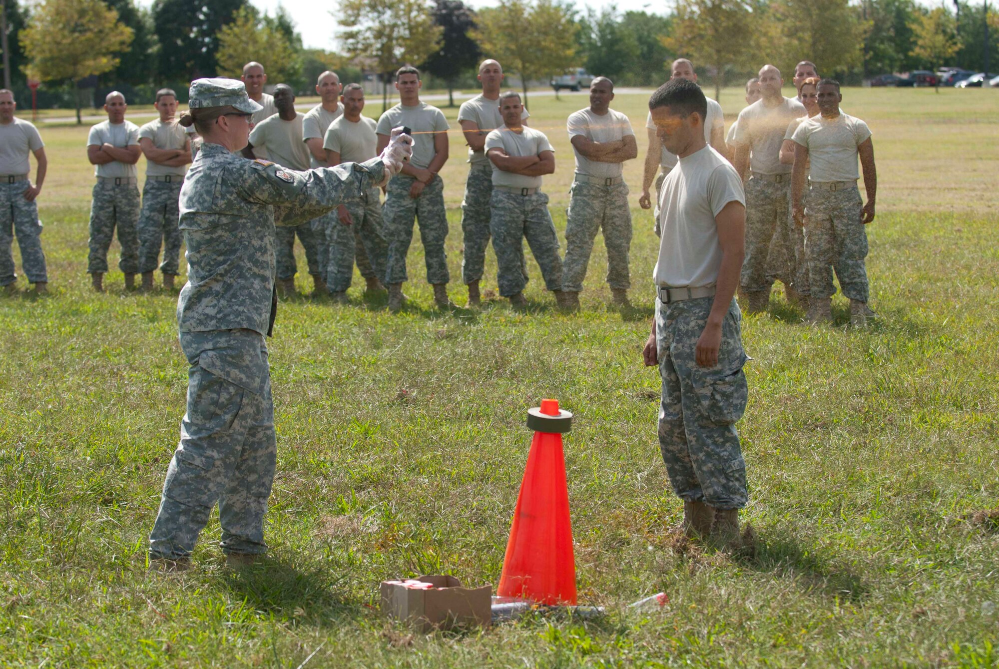 Staff Sgt. April Chambliss, 174th Infantry Brigade trainer/mentor, sprays a mobilizing military police Soldier with Oleoresin Capsicum, or "OC" spray during mobilization training Sep. 9, 2013, at Joint Base McGuire-Dix-Lakehurst, N.J. Other Soldiers from the 480th Military Police Company, Puerto Rico Army National Guard, watch and wait their turns to be sprayed and complete the subsequent tactics course. After being sprayed, the MPs complete five stations where they engage combatants, strike, block strikes, perform take-downs and subdue combatants, all the while feeling the effects of the OC spray themselves. "MPs have to learn to deal with cross-contamination," said Chambliss," so that at any point they know they are still capable of subduing their subject even if hit with the OC themselves." First Army ensures mobilization training is relevant, realistic and reflects the most current conditions Soldiers will face in theater. First Army Division East directly supports the Chief of Staff of the Army's priority of providing trained, equipped and ready forces to win the current fight, while maintaining responsiveness to unforeseen contingencies. (U.S. Army photo by Sgt. 1st Class Stan Maszczak/Released)