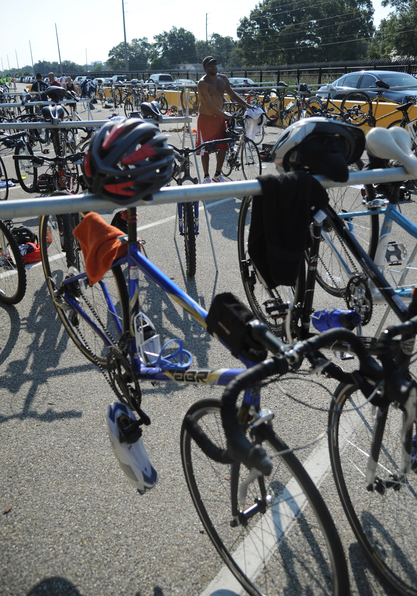 Miguel Rivera-Ainaga, Keesler life guard, strolls his bicycle through bike racks as he completes the Keesler's mini-triathlon Sept. 13, 2013, at Keesler Air Force Base, Miss.  The event consists of a 9-mile bike ride, a 2-mile run and a 200-yard swim.  (U.S. Air Force photo by Kemberly Groue)