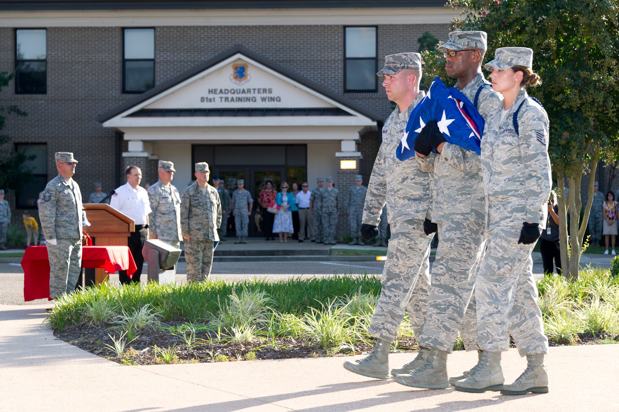 Tech. Sgt. Kyle Mullen, 81st Training Group military training leader, and Staff Sgts. Issac Kendrick, 336th Training Squadron MTL, and Victoria Brady, 338th Training Squadron MTL, complete a flag folding ceremony during a retreat ceremony Sept. 11, 2013, Keesler Air Force Base, Miss. The ceremony honored those who lost their lives during the 9/11 attacks.  (U.S. Air Force photo by Adam Bond)