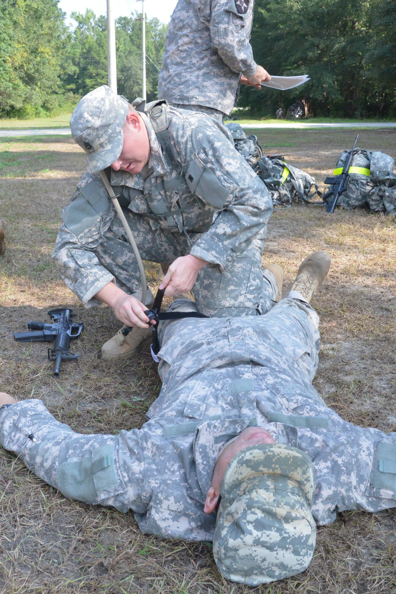 Soldiers with the Army’s 138th Military Intelligence Co. practice medical training while taking cover under enemy attack. (U.S. Air Force photo by Ray Crayton)