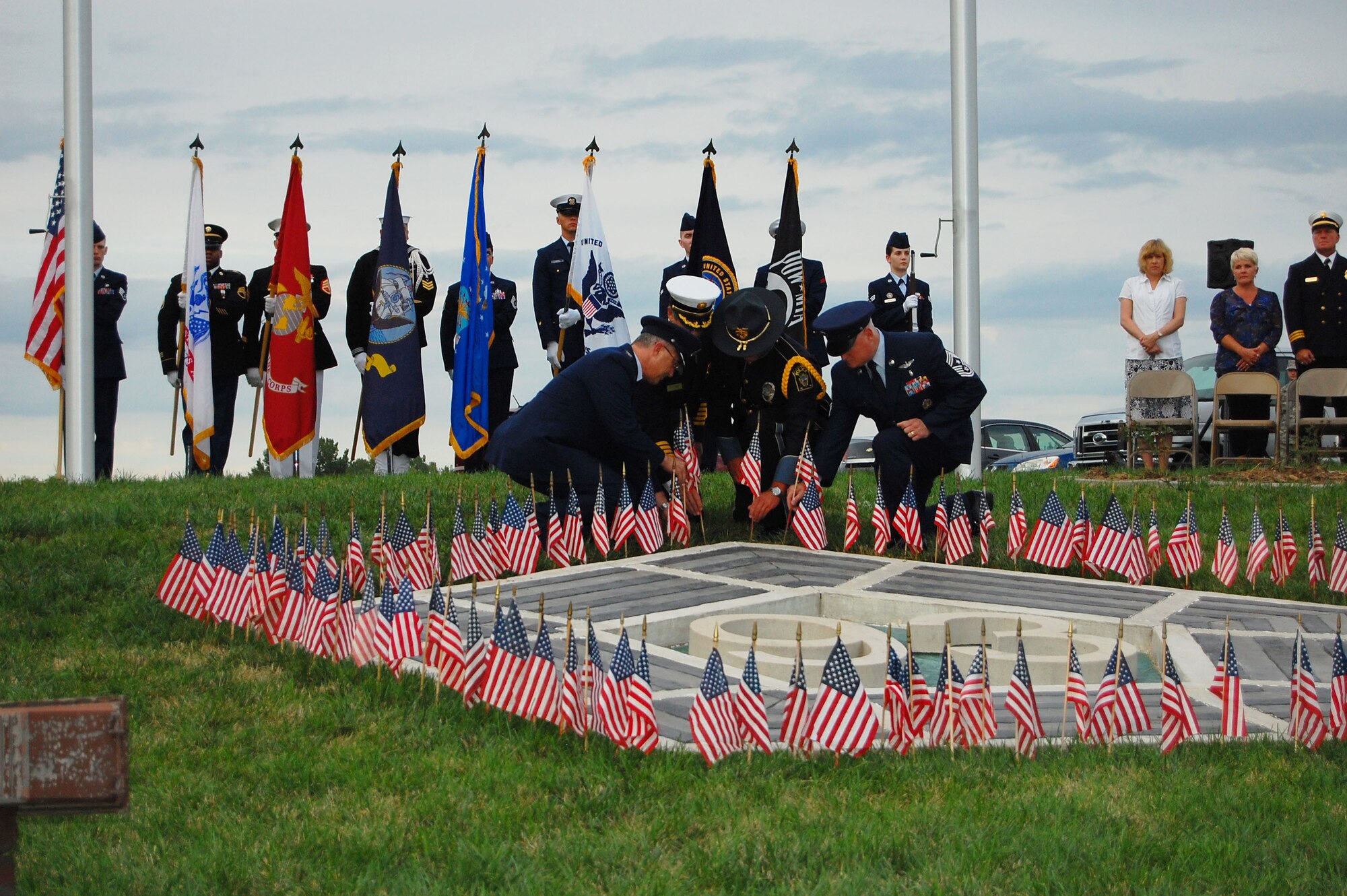 U.S. Air Force Col. Hans Palaoro, 55th Wing vice commander,  Perry Guido, Bellevue Fire Department fire chief, Detective Roy Howell, Bellevue Police Department, and U.S. Air Force Chief Master Sgt. William Thomaston, 55th Wing command chief, place flags as part of a 9/11 ceremony at American Heroes Park in Bellevue, Neb., on Sept. 11. The memorial with two flagpoles and a pentagon with the number 93 inside honors those lost on 9/11 in the two towers of the World Trade Center in New York, the Pentagon in Washington D.C. and Flight 93 that crashed in a field in Pennsylvania. (U.S. Air Force photo by Mark Borytsky/Released)
