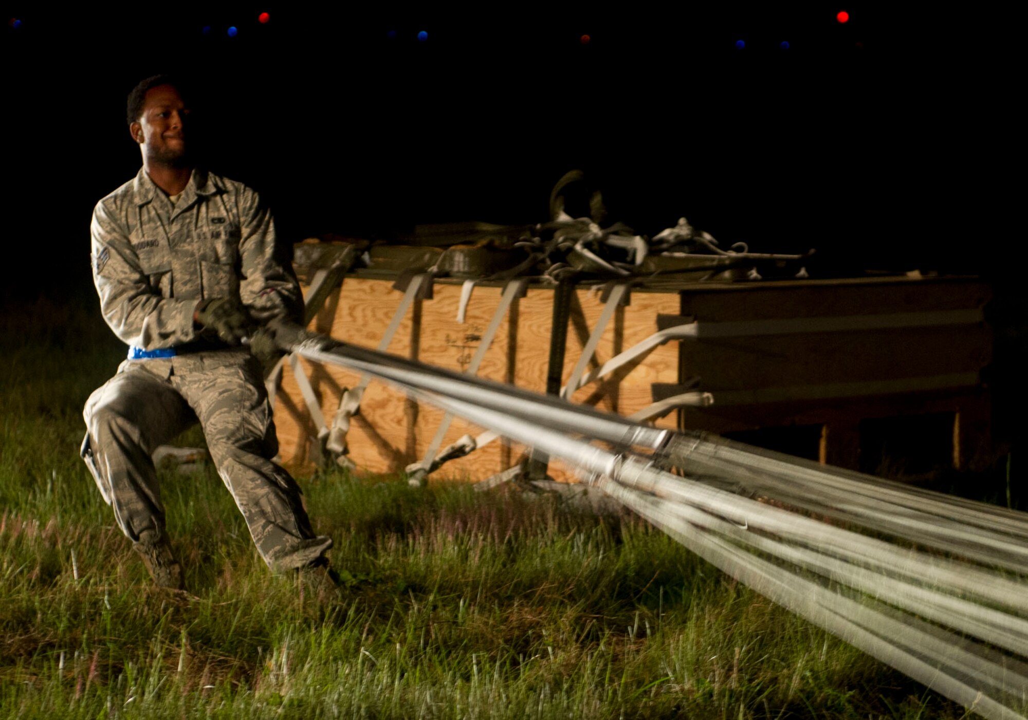 QUONSET POINT AIR NATIONAL GUARD STATION, R.I. - Senior Airman Jordan Woodard, 818th Contingency Response Group aerial porter, recovers airdropped cargo during a low cost training here, Sept. 5, 2013. The training included loading and unloading, day and night engine running offload, night vision operations, combat offloads, maintenance familiarization, drop zone recovery, command and control, and full spectrum communications. (U.S. Air Force photo by Staff Sgt. Gustavo Gonzalez)