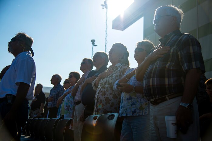 Members of the crowd place their hands over their hearts while the National Anthem is sung during a ceremony commemorating the delivery of the final U.S. Air Force C-17 Globemaster III, P-223, Sept. 12, 2013, on the flight line at Joint Base Charleston - Air Base, S.C. This historical event comes more than 20 years after the 437th Airlift Wing and the 315th Airlift Wing took delivery of the very first C-17 to enter the Air Force inventory June 14, 1993 and marks the successful completion of C-17 production for the U.S. Air Force. (U.S. Air Force photo/ Senior Airman George Goslin)