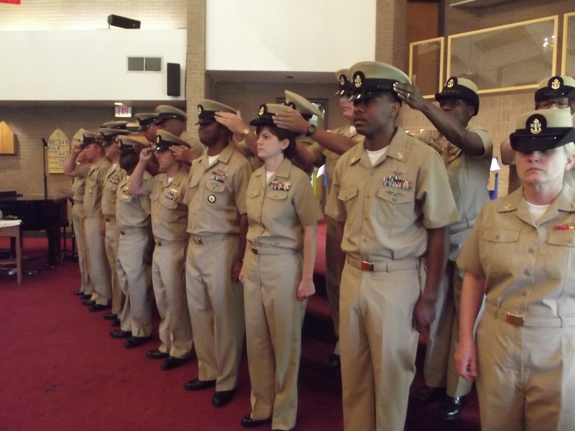 Nine of Charleston’s newest chief petty officers are fitted with their combination covers shortly after being pinned with their anchors during the LowCountry Chief Petty Officers pinning ceremony Sept. 13, 2013, at All Saints Chapel on Joint Base Charleston -  Weapons Station. Traditionally, the chief selects’ sponsors place the combination covers on the newly pinned chiefs, signifying the passing of naval tradition from one chief petty officer to the next generation of leaders. Chief petty officer pinning ceremonies were also held Sept. 13, at the Bowman Center on the campus of the Naval Nuclear Power Training Command and at the Red Bank Club for the Naval Nuclear Power Training Unit Sailors promoted to chief petty officer. (U.S. Navy photo/Eric Sesit)  