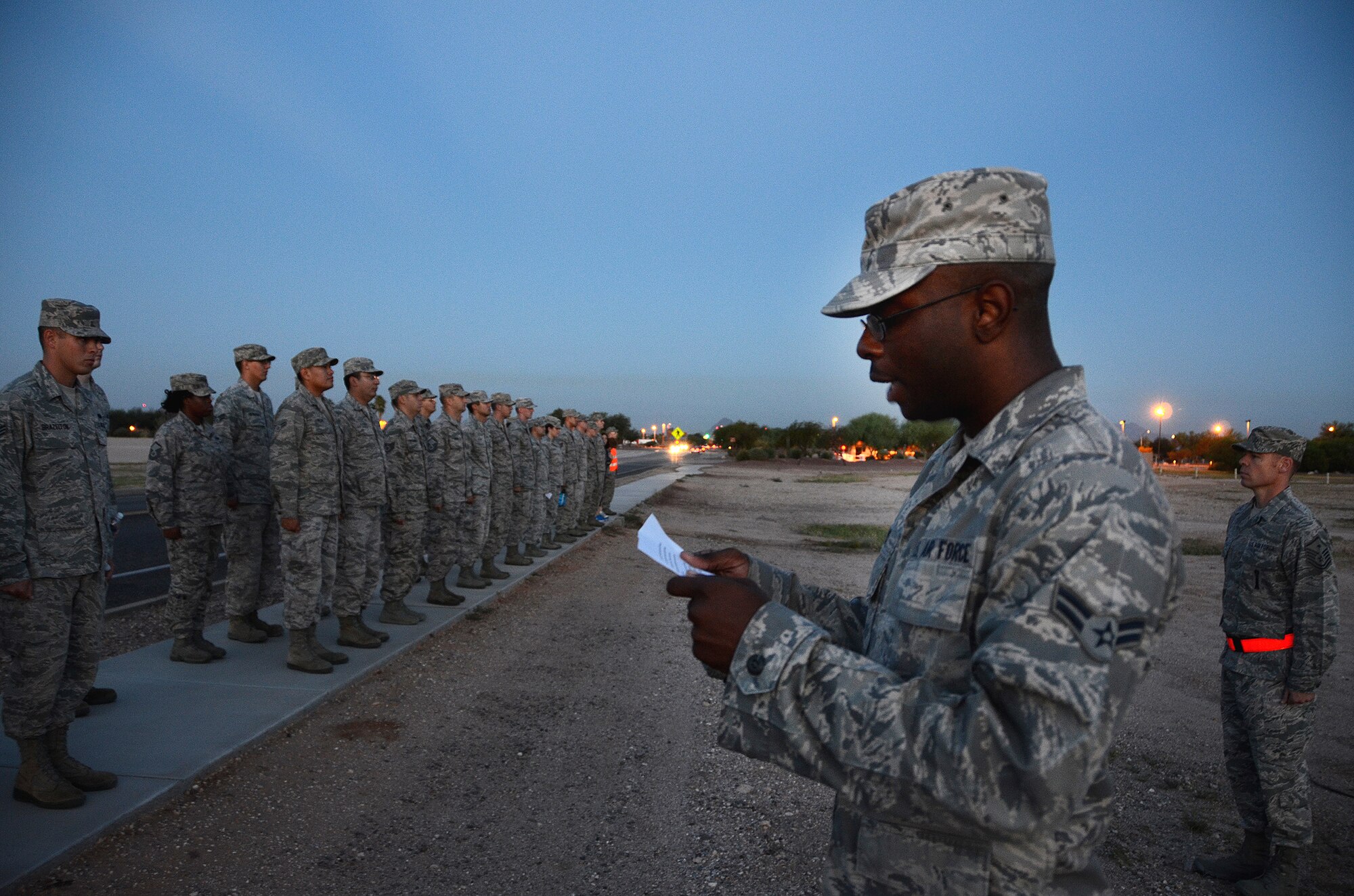 Airman 1st Class Markeith Davis, member of the 612th Air Communication Squadron (ACOMS), reads a description of American Airlines Flight 11 during the first stop of the 612th ACOMS memorial march around Davis-Monthan AFB, Ariz., Sept. 11, 2013.  The squadron stopped at 8:46 a.m. (EST) as a remembrance of the first aircraft to hit the North Tower of the World Trade Center. (USAF photo by Staff Sgt. Heather Redman/Released)