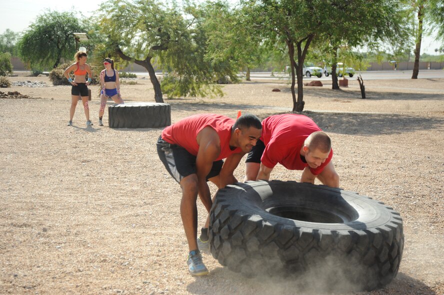 Semmi Quarles, left, 56th Operations Group intelligence readiness journeyman, and Michael Koepke, 56th Operations Support Squadron intelligence operations officer-in-charge, members of Team Intel, work together to accomplish the fourth obstacle in the Warrior PT Challenge Sept. 6 at Luke Air Force Base. Team Intel placed 5th out of 13, the best scoring team from Luke. (U.S. Air Force photo/Airman 1st Class Pedro Mota)