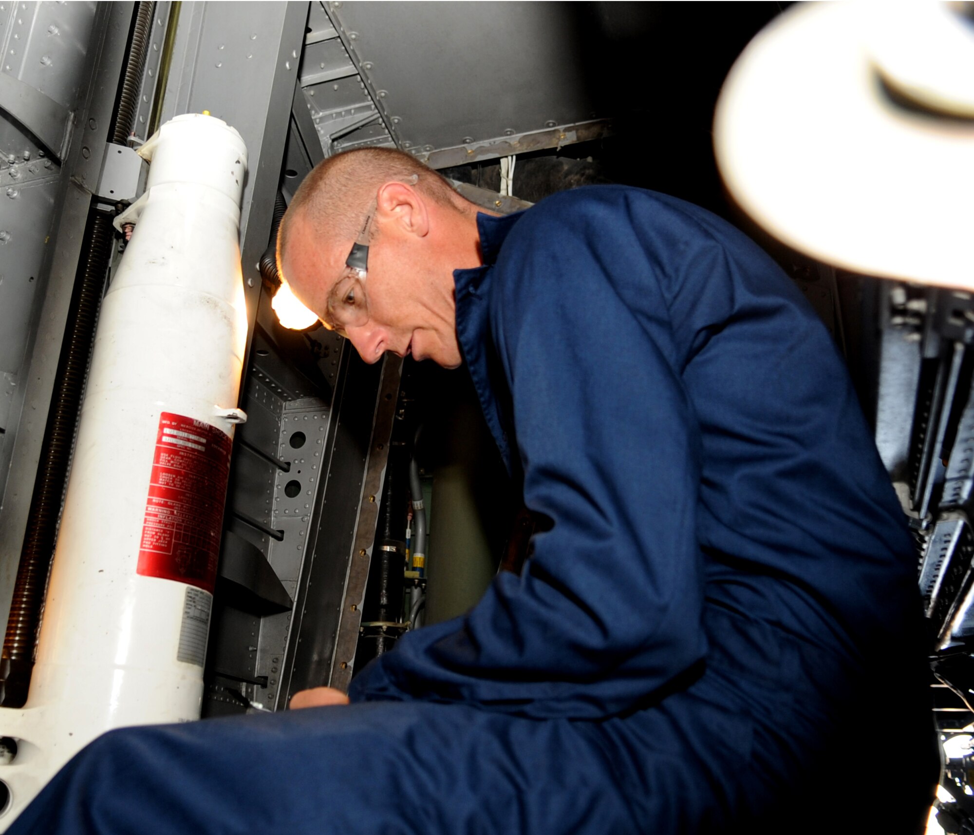 U.S. Air Force Col. Jeffrey Brown, 317th Airlift Group commander, sits under a wing on a C-130J Sept. 6, 2013, at the Global Reach for America hangar on Dyess Air Force Base, Texas. Brown advised his group that if anyone could beat him in a run, he would do their job for two hours. Senior Airman Sean Hopkins, 317th Maintenance Squadron, took him up on that challenge and ran his mile-and-a-half in an 8:17, while the Brown finished with an 8:51. (U.S. Air Force photo by Senior Airman Shannon Hall/Released)