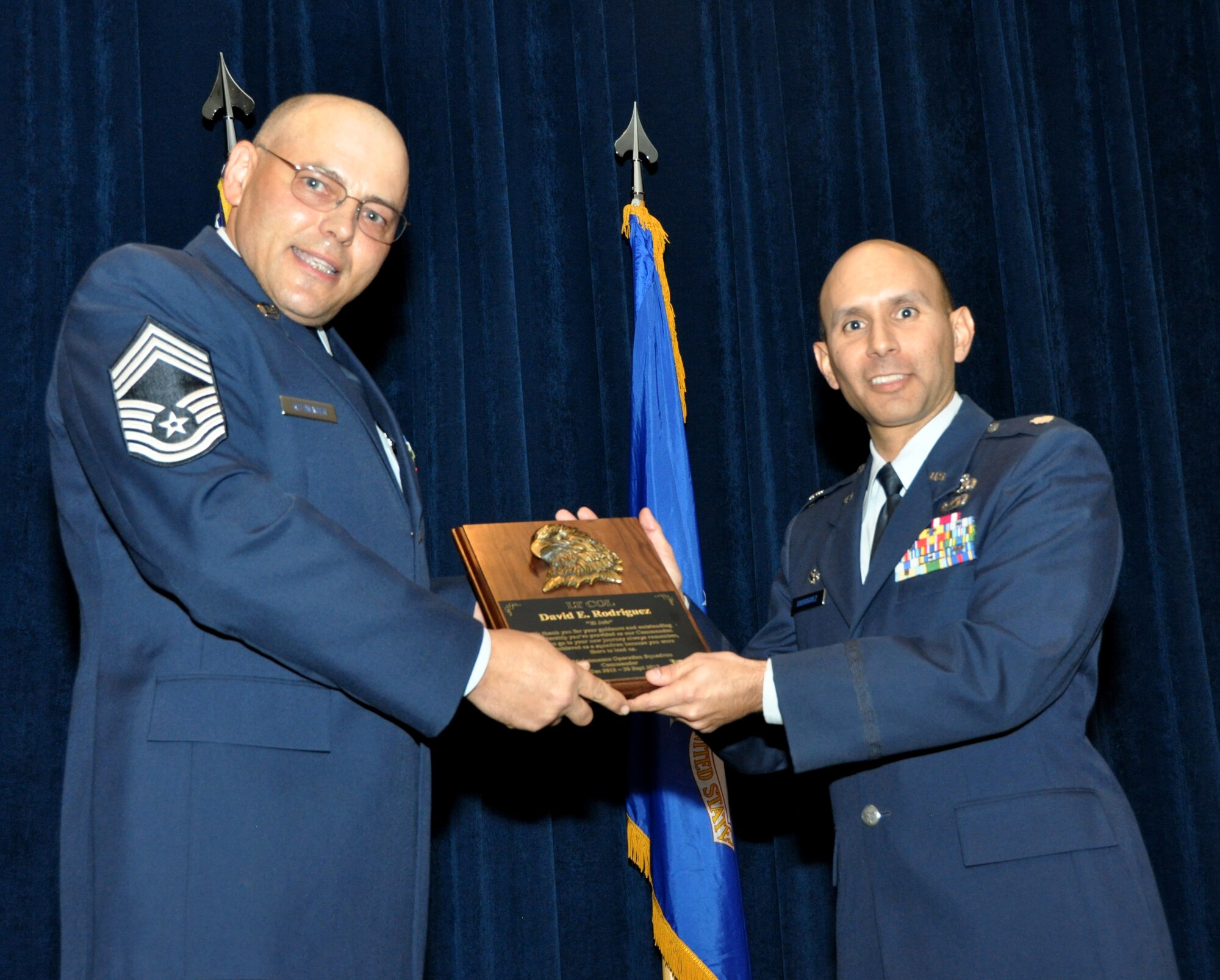 Chief Master Sgt. Anthony Rittwager from the 433rd Maintenance Operation Squadron presents Lt. Col. David Rodriguez, commander of the 433rd Maintenance Operation Squadron, with a token of appreciation during the MOS inactivation ceremony, Sept. 8, 2013 on Joint Base San Antonio-Lackland, Texas. MOS will merge with the 433rd Maintenance Operation Group, effective Oct.1, 2013. (U.S. Air Force Photo/Staff Sgt. Sarah Pullen)