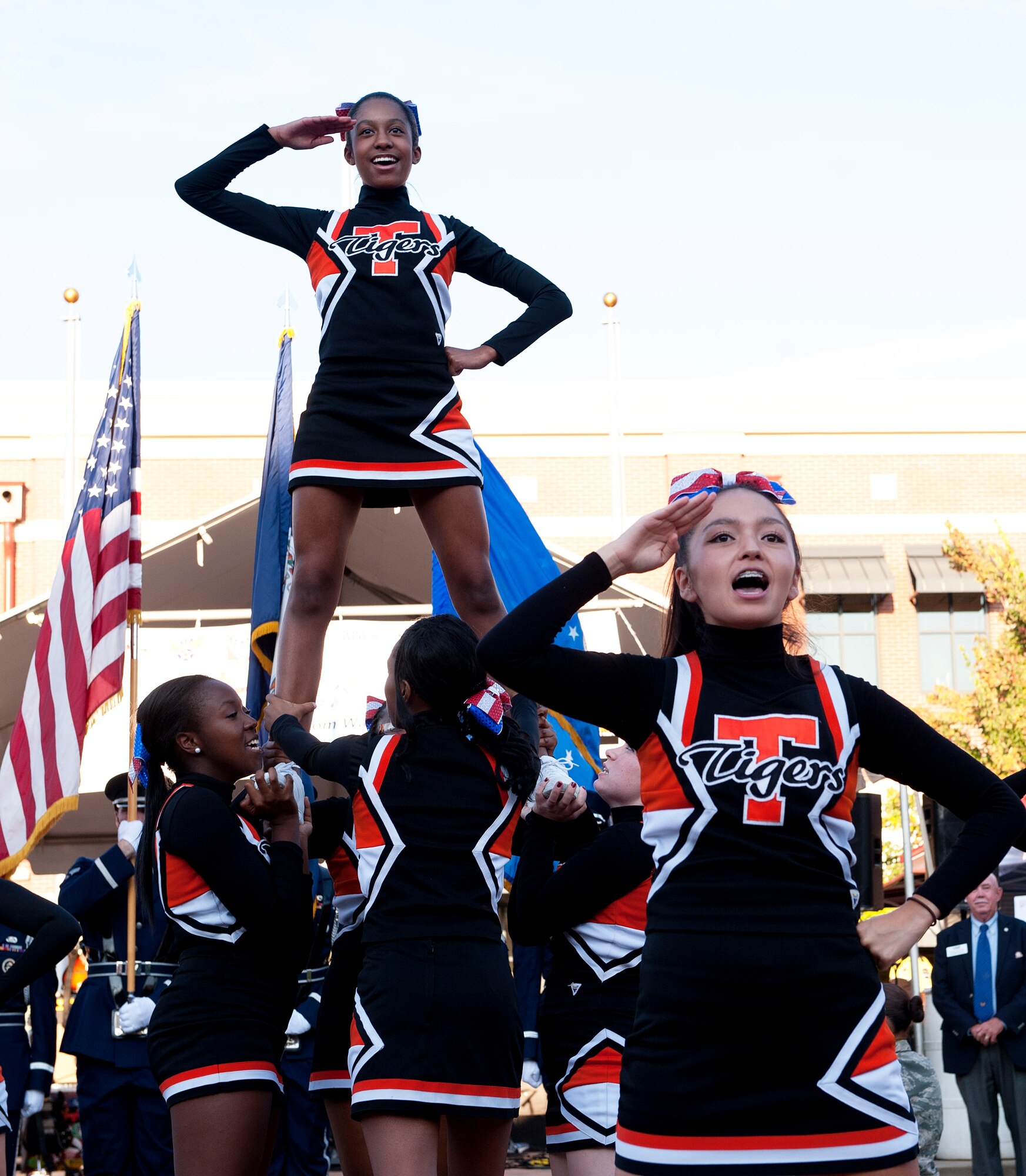 Cheerleaders Geline Preudhomme and Jennifer Melfie from Tabb High School salute service members at the September 11 memorial ceremony Sept. 11, 2013 in Hampton, Va. Preudhomme  says 9/11 is a day to remember those who serve to keep us safe and free. (U.S. Air Force Photo/Sachel Seabrook)