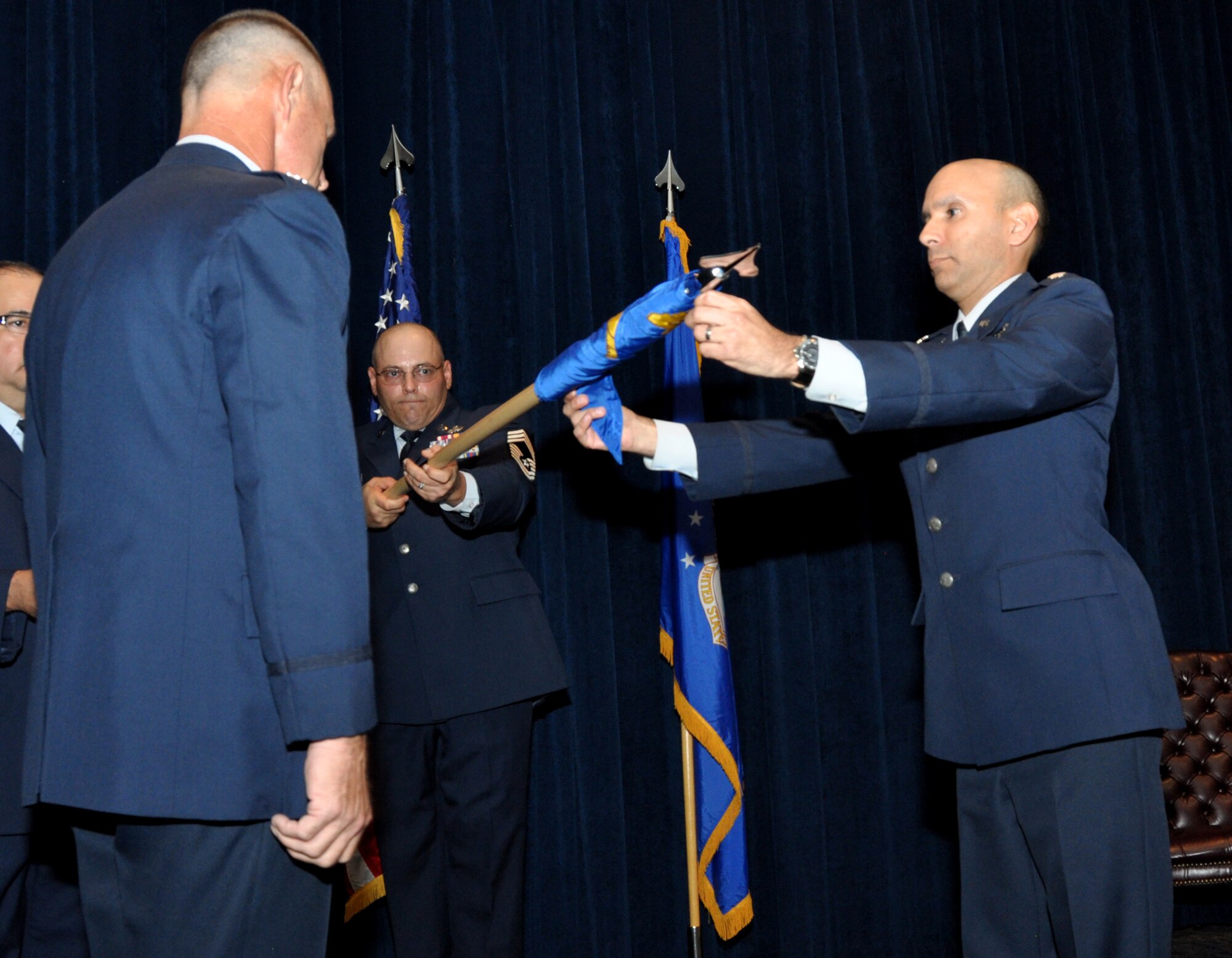 The 433rd Maintenance Operation Squadron from Joint Base San Antonio-Lackland, Texas watches Lt. Col David Rodriquez, (right) 433rd Maintenance Operation Squadron commander, furl the squadron’s guidon as Col. Charles Combs, 433rd Maintenance Group commander looks on during an inactivation ceremony Sept. 8, 2013. MOS will become part of the 433rd Maintenance Group’s Maintenance Operations Section effective October 1, 2013. (U.S. Air Force Photo/Staff Sgt. Sarah Pullen)