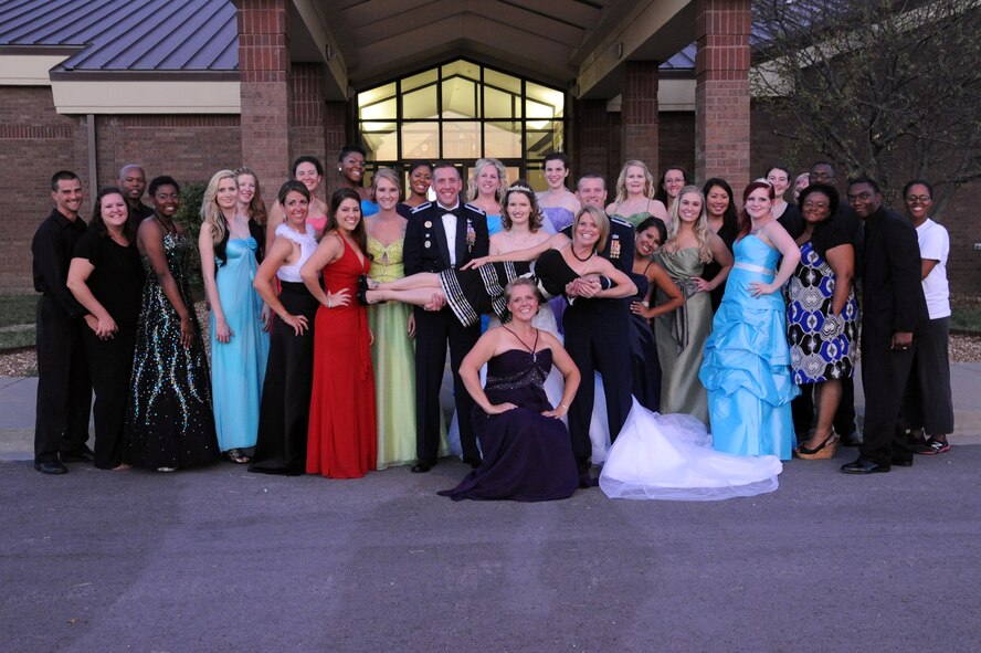 Models and volunteers of the B-2 Fabulous Fashion Show pose for a group photo at the end of the night at Whiteman Air Force Base, Mo., Sept. 6, 2013. The show was put on entirely by volunteers who put in long hours in practices and committee meetings. (U.S. Air Force photo by Airman 1st Class Shelby R. Orozco/Released)