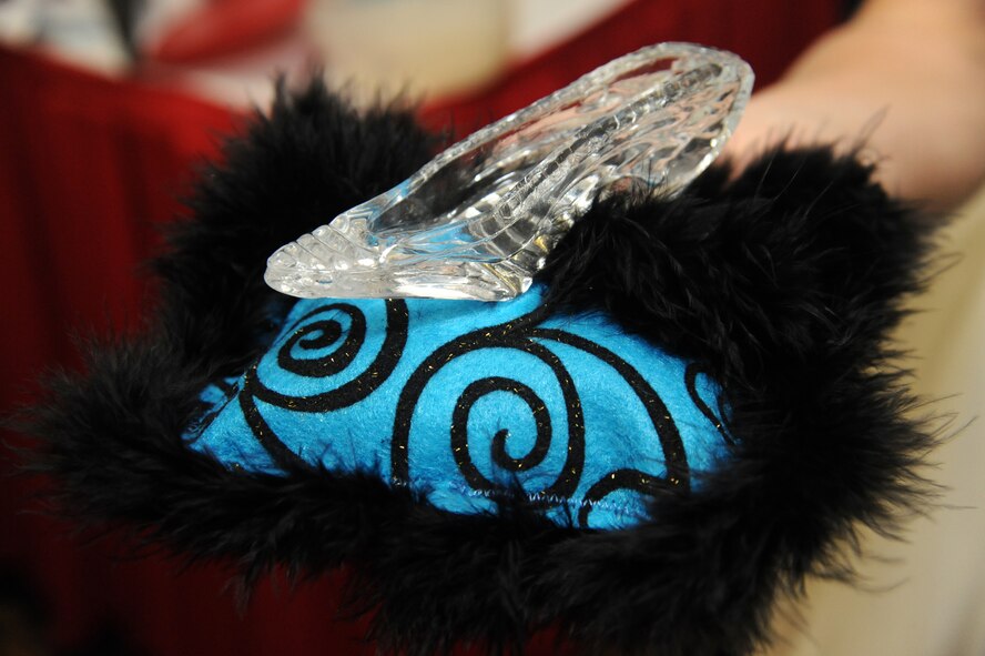 A glass slipper is presented to Lori Hornback, wife of Air Force Global Strike Command Chief Chief Master Sgt. Brian Hornback, at the B-2 Fabulous Fashion Show at Whiteman Air Force Base, Mo., Sept. 6, 2013. She created the Cinderella’s Closet program in 2006 when she realized many women were not going to events such as Air Force balls because they could not afford gowns and accessories to wear to the events. (U.S. Air Force photo by Airman 1st Class Shelby R. Orozco/Released)