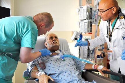 Elliot D. Buffington, a patient in San Antonio Military Medical Center's Surgical Intensive Care Unit, receives trach care from SICU student, Army Sgt. Richard McCollough as SICU Instructor and Registered Respiratory Therapist, Raul Questell oversees the cleaning. (Army photo by Robert Shields, Brooke Army Medical Center Public Affairs)