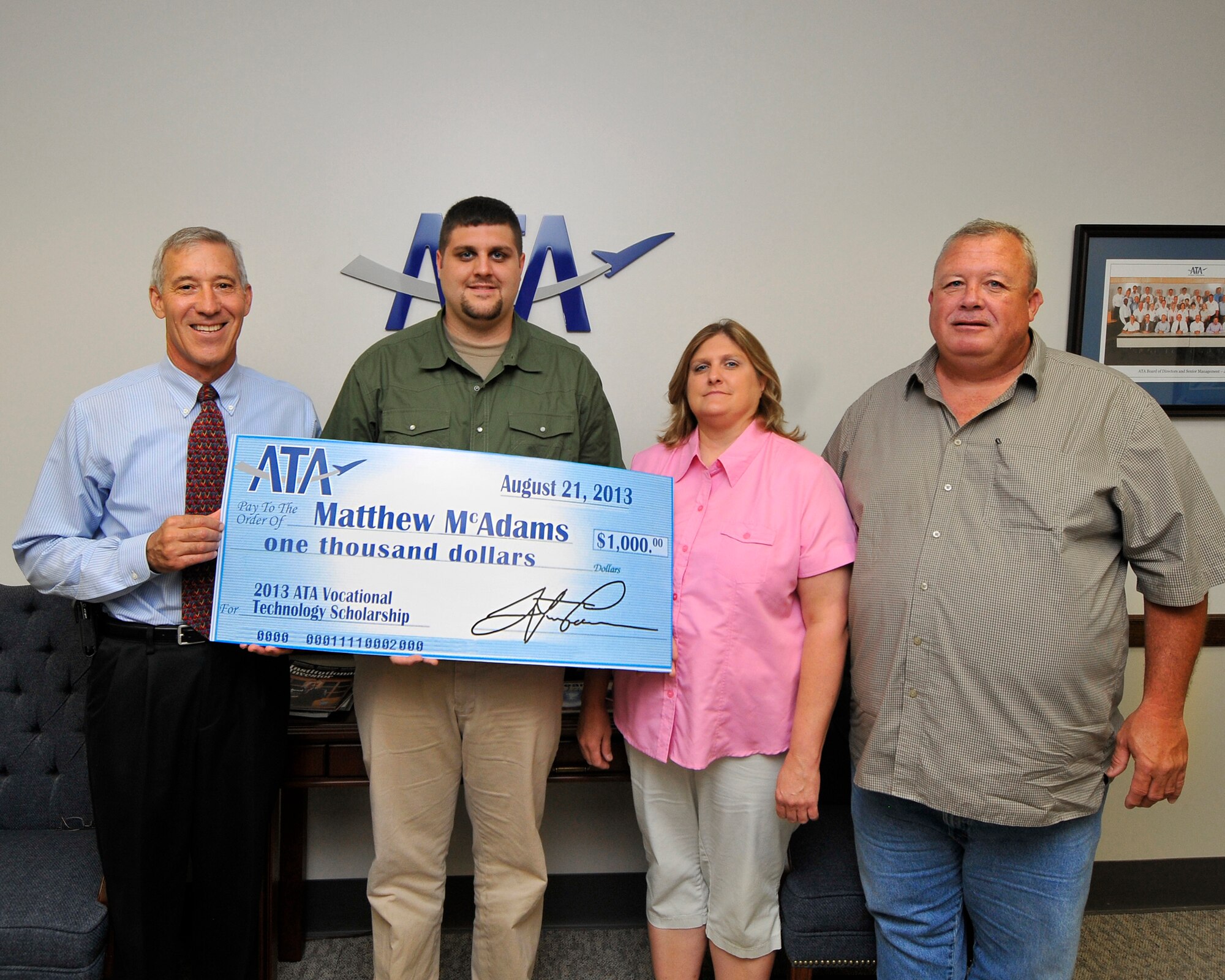 Matt McAdams (second from left) accepts a $1,000 ATA Vocational Technology Scholarship from ATA Deputy General Manager Phil Stich (left). Matt is joined by his father and ATA employee Aaron McAdams (right) and mother Shannoah McAdams. (Photo by Jacqueline Cowan)