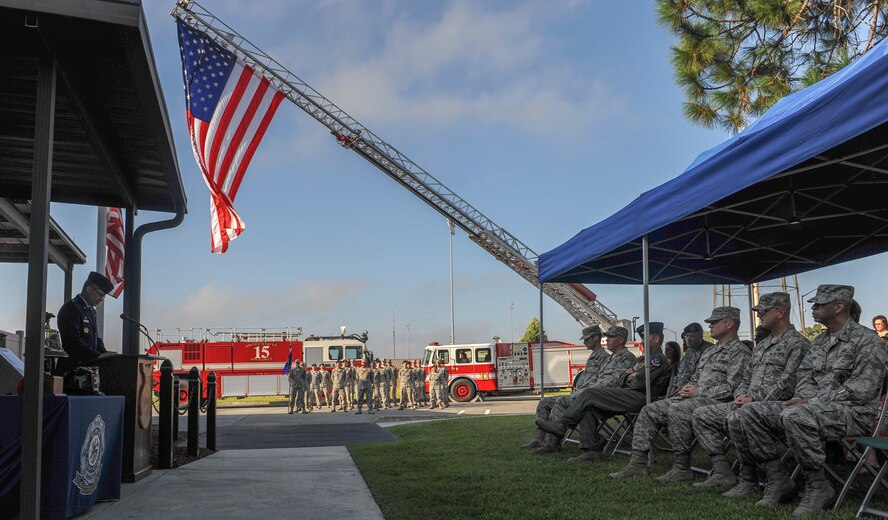 Airmen sit in silence as U.S. Air Force Lt. Col. Patrick Albritton, 23d Civil Engineer Squadron commander, shares his story during a 9/11 memorial ceremony at Moody Air Force Base, Ga., Sept. 11, 2013. The fire department held the ceremony to honor and remember the many lives who were lost that day and the thousands of lives lost fighting the Global War on Terrorism.(U.S. Air Force photo by Airman Alexis Grotz/Released)