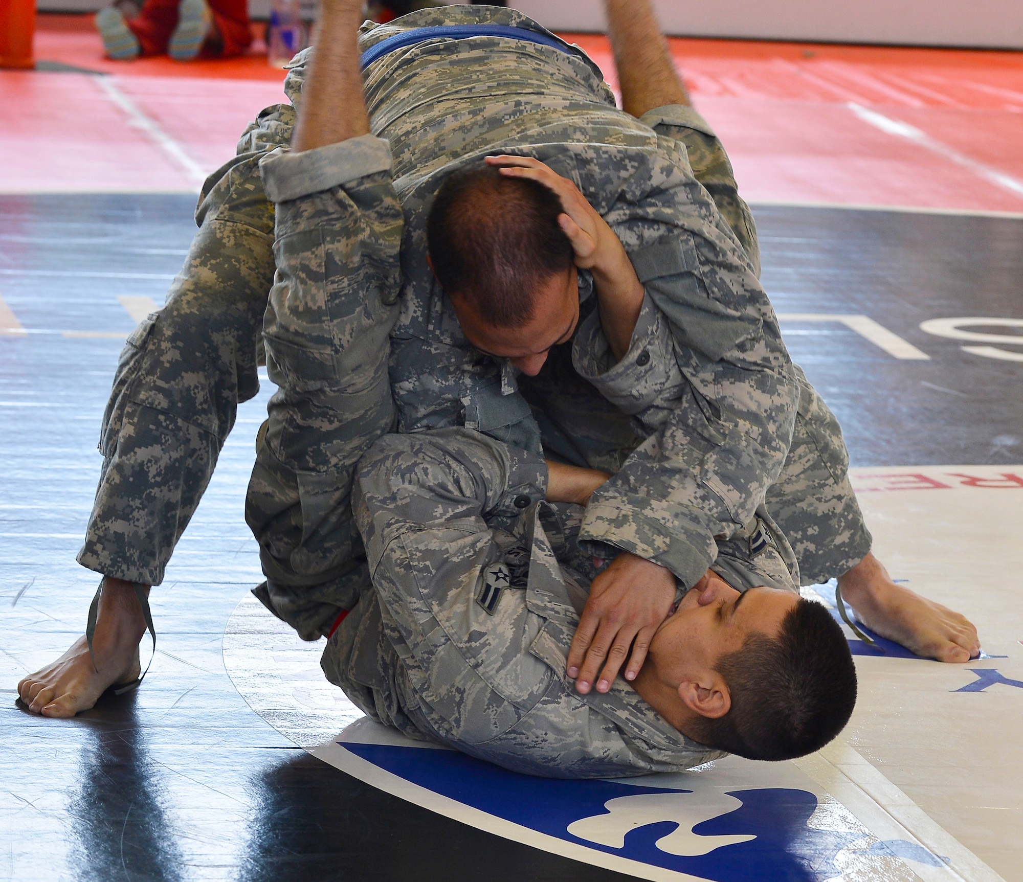 Airmen 1st Class Kazuhito Ikematsu, 1st Combat Communications Squadron radio frequency transmissions technician, attempts a triangle choke hold during a combatives tournament, Sept. 7, 2013. Kleber Kaserne Fitness Center, Germany. (U.S. Air Force photo/Airman Dymekre Allen)