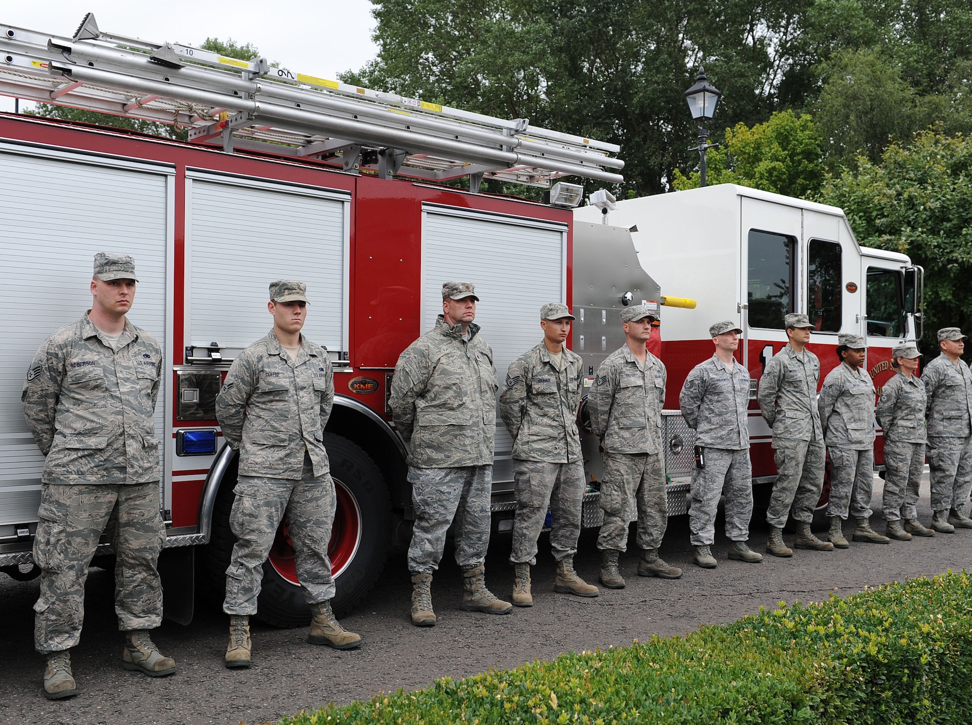 Team Mildenhall members wait for retreat to sound Sept. 11, 2013, in front of a fire truck on RAF Mildenhall, England. Retreat typically takes place on the last Friday of every month, but RAF Mildenhall held a ceremonial retreat in honor of those who died in the 9/11 attacks. Airmen with family or close friends who are first responders were encouraged to break ranks and stand in front of their respective first-responder vehicle. (U.S. Air Force photo by Airman 1st Class Preston Webb/Released)