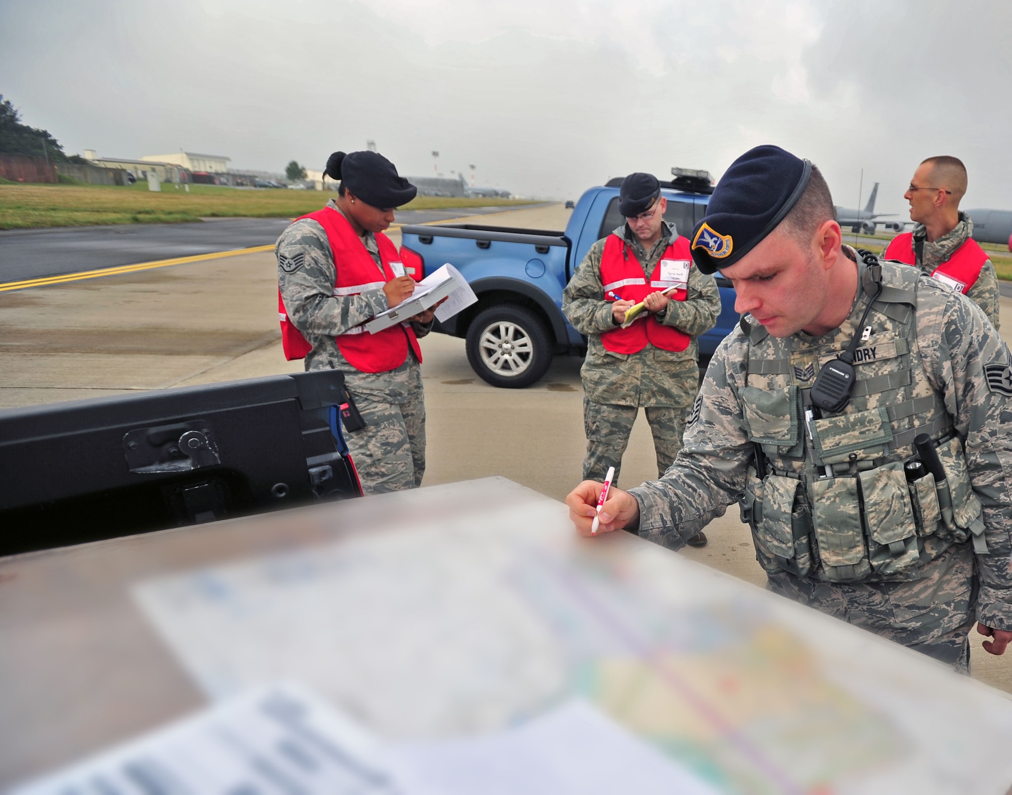 U.S. Air Force Staff Sgt. Beau Hendry, front, 100th Security Forces
Squadron, uses a map to set a perimeter around the flightline during an
operational readiness inspection Sept. 12, 2013, on RAF Mildenhall, England.
During the ORI, the 100th SFS Airmen responded to a fuel spill on the
flightline. The ORI prepares Airmen for potential real-world scenarios. (U.S.
Air Force photo by Senior Airman Christine Griffiths/Released) (Photo
altered for security.)