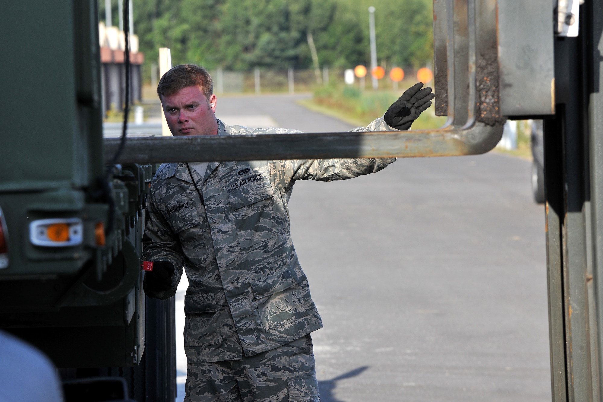 Senior Airman Matthew Dankiewicz, 86th Munitions Squadron munitions storage crew member, performs spotter duty to ensure munitions are loaded safely onto a trailer, Aug. 22, 2013, Ramstein Air Base, Germany.  The Precision Guided Munitions shop maintains five missile systems comprised of 730 All-Up-Round missiles and associated components worth a total of $193.2 million. (U.S. Air Force photo/Senior Airman Chris Willis)