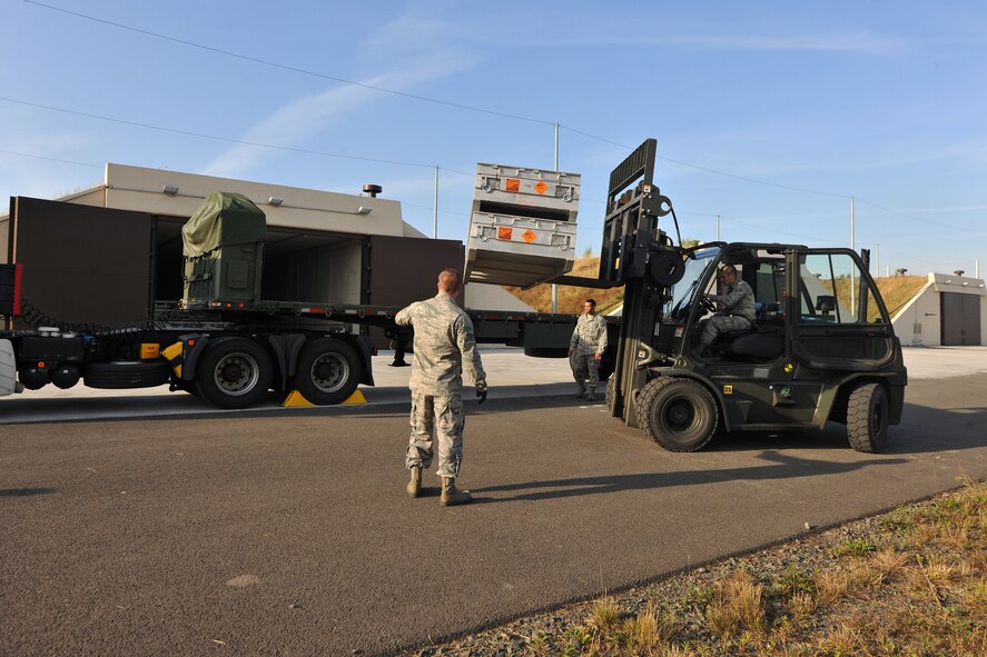 Staff Sgt. Brian Warner, Senior Airman Matthew Dankiewicz, and Airman 1st Class David Shelton, 86th Munitions Squadron munitions storage crew members, load munitions onto a trailer for transport, Aug. 22, 2013, Ramstein Air Base, Germany.  The munitions will be transported to an intransit munitions facility where they will be shipped out in support of worldwide operations.  (U.S. Air Force photo/Senior Airman Chris Willis)