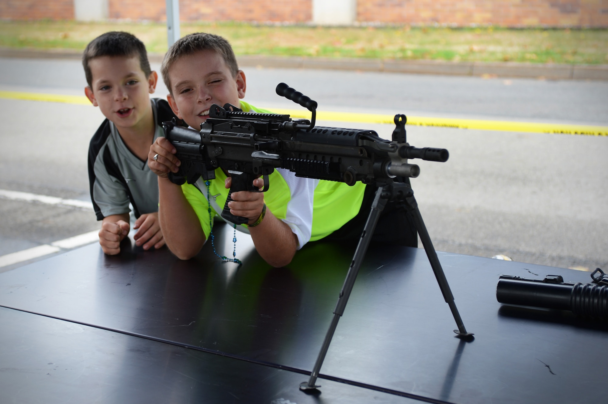 Weston and Kaiden Bodkin, sons of Staff Sgt. Clayton Bodkin, 700th Contracting Squadron unit deployment manager, interact with weapons on display during the 2013 Day for Kids, Sept. 7, 2013, Ramstein Air Base, Germany. The Ramstein’s youth program and the Boys and Girls Club of America sponsored the event with the purpose of bringing parents and their children together to have a good time. (U.S. Air Force photo/Senior Airman Caitlin Guinazu)