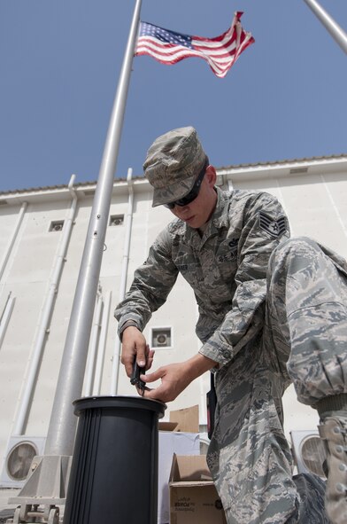 U.S. Air Force Staff Sgt. Eric Tucker, 380th Expeditionary Civil Engineer Squadron electrical systems craftsman, works on a replacement light for the wing headquarter’s flag pole at an undisclosed location in Southwest Asia Sept. 11, 2013. The light is placed in the ground and shoots a beam of light straight up towards the flag to light it at night. Tucker calls Fleming County, Ky., home and is deployed from Travis Air Force Base, Calif. (U.S. Air Force photo by Staff Sgt. Jacob Morgan)