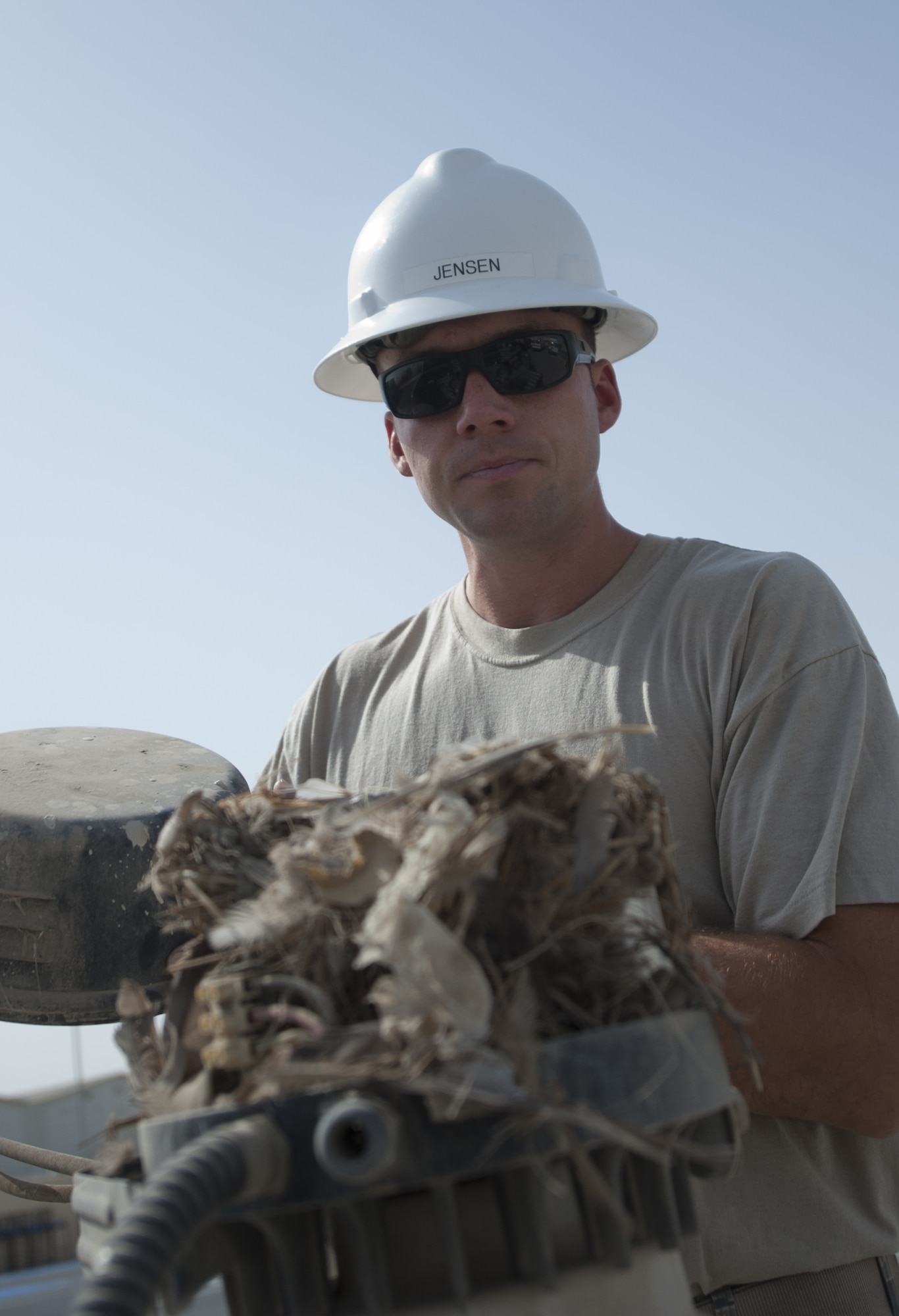 U.S. Air Force Staff Sgt. Erick Jensen, 380th Expeditionary Civil Engineer Squadron electrical systems craftsman, opens an old light used at the Thirsty Camel to find a bird’s nest at an undisclosed location in Southwest Asia Sept. 11, 2013. The electrical systems shop is in the process of replacing older outdoor lighting with new light emitting diode and solar powered lights. Jensen calls Wausau, Wis., home and is deployed from Ellsworth Air Force Base, S.D. (U.S. Air Force photo by Staff Sgt. Jacob Morgan)
