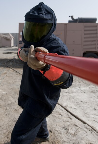 U.S. Air Force Senior Airman Tim Radke, 380th Expeditionary Civil Engineer Squadron electrical systems journeyman, uses an insulated grip-all hot stick to replace a plug on a generator at an undisclosed location in Southwest Asia Sept. 11, 2013. When power is live, electrical systems technicians are required to wear an arc flash suit due to the possibility of an electrical arc flash occurring. Radke calls Citrus County, Fla., home and is deployed from Joint Base McGuire-Dix-Lakehurst, N.J (U.S. Air Force photo by Staff Sgt. Jacob Morgan)