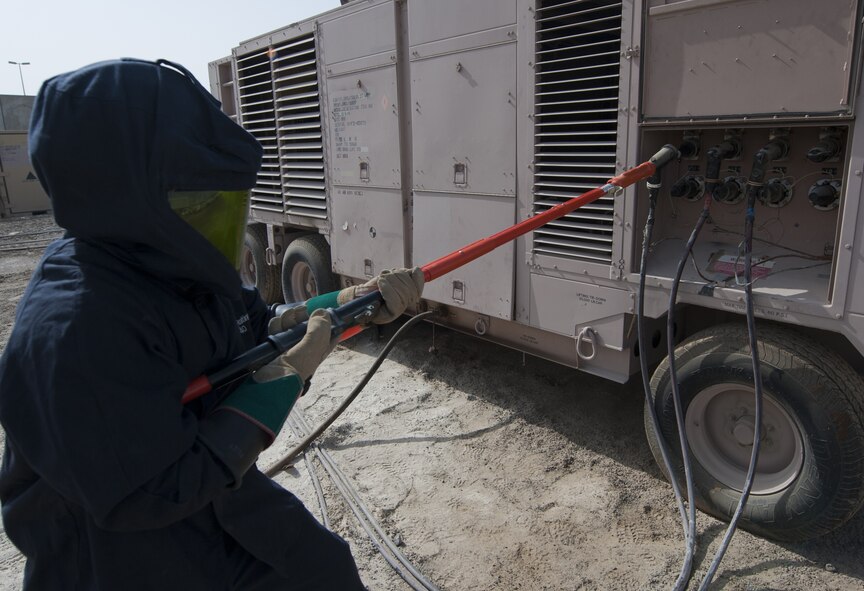 U.S. Air Force Senior Airman Tim Radke, 380th Expeditionary Civil Engineer Squadron electrical systems journeyman, uses an insulated grip-all hot stick to remove a plug on a generator at an undisclosed location in Southwest Asia Sept. 11, 2013. When power is live, electrical systems technicians are required to wear an arc flash suit due to the possibility of an electrical arc flash occurring. Radke calls Citrus County, Fla., home and is deployed from Joint Base McGuire-Dix-Lakehurst, N.J. (U.S. Air Force photo by Staff Sgt. Jacob Morgan)