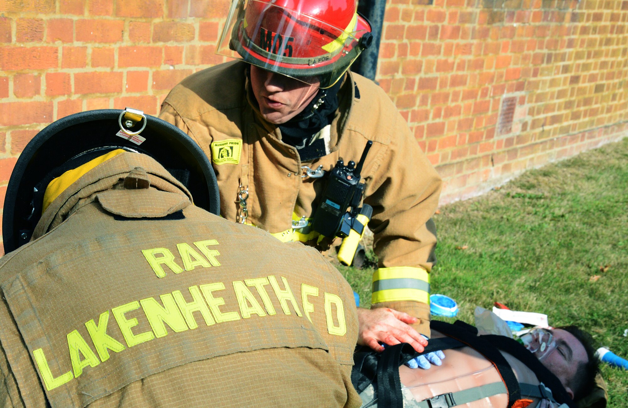 Firefighters from the 48th Civil Engineer Squadron, led by Staff Sgt. Tyler Mclain (red helmet), treat simulated patient Dave Scott, 48th Medical Group medical simulation technician, for wounds received during an active-shooter exercise on Royal Air Force Feltwell, England, Sept. 5, 2013. Responders from 48th Security Forces Squadron, 48th CES Explosives Ordnance Disposal and 48th CES Fire Department were evaluated during the training by the 48th Fighter Wing Inspection Team. (U.S. Air Force photo by Staff Sgt. Thomas Trower/Released)
