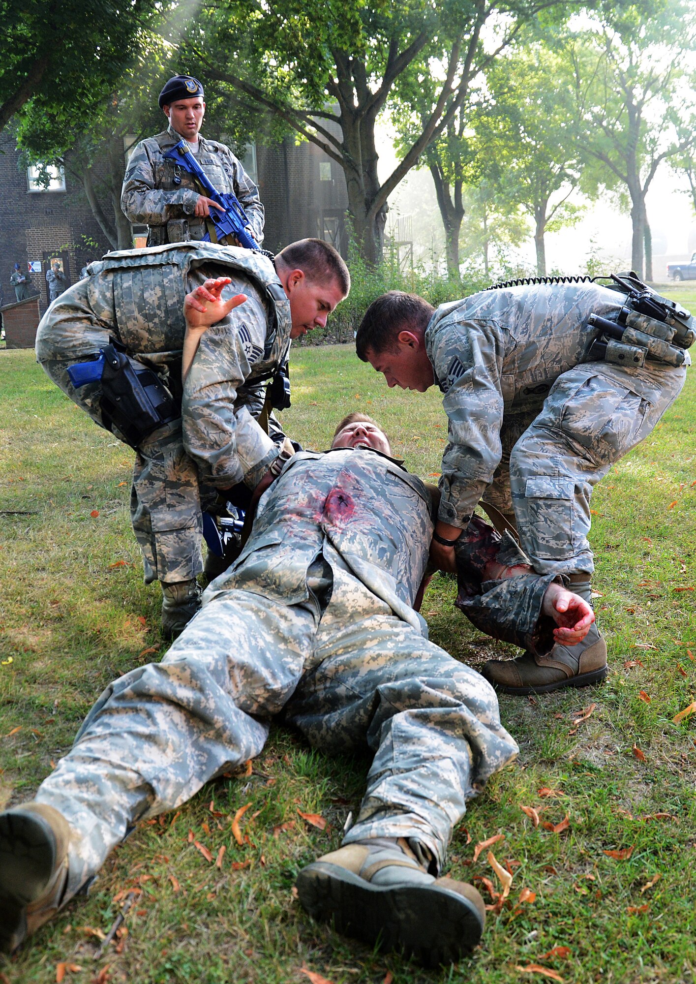 Staff Sgts. Adam Battin and Trevor Brewer, both 48th Security Forces Squadron patrolmen, drag simulated patient Dave Scott, 48th Medical Group medical simulation technician, to safety while Staff Sgt. Brent Bechtel, 48th SFS patrolman, provides overwatch during an active-shooter exercise on Royal Air Force Feltwell, England, Sept. 5, 2013. Responders from 48th SFS, 48th Civil Engineer Squadron Explosives Ordnance Disposal and 48th CES Fire Department were evaluated on their execution by the 48th Fighter Wing Inspection Team. (U.S. Air Force photo by Staff Sgt. Thomas Trower/Released)