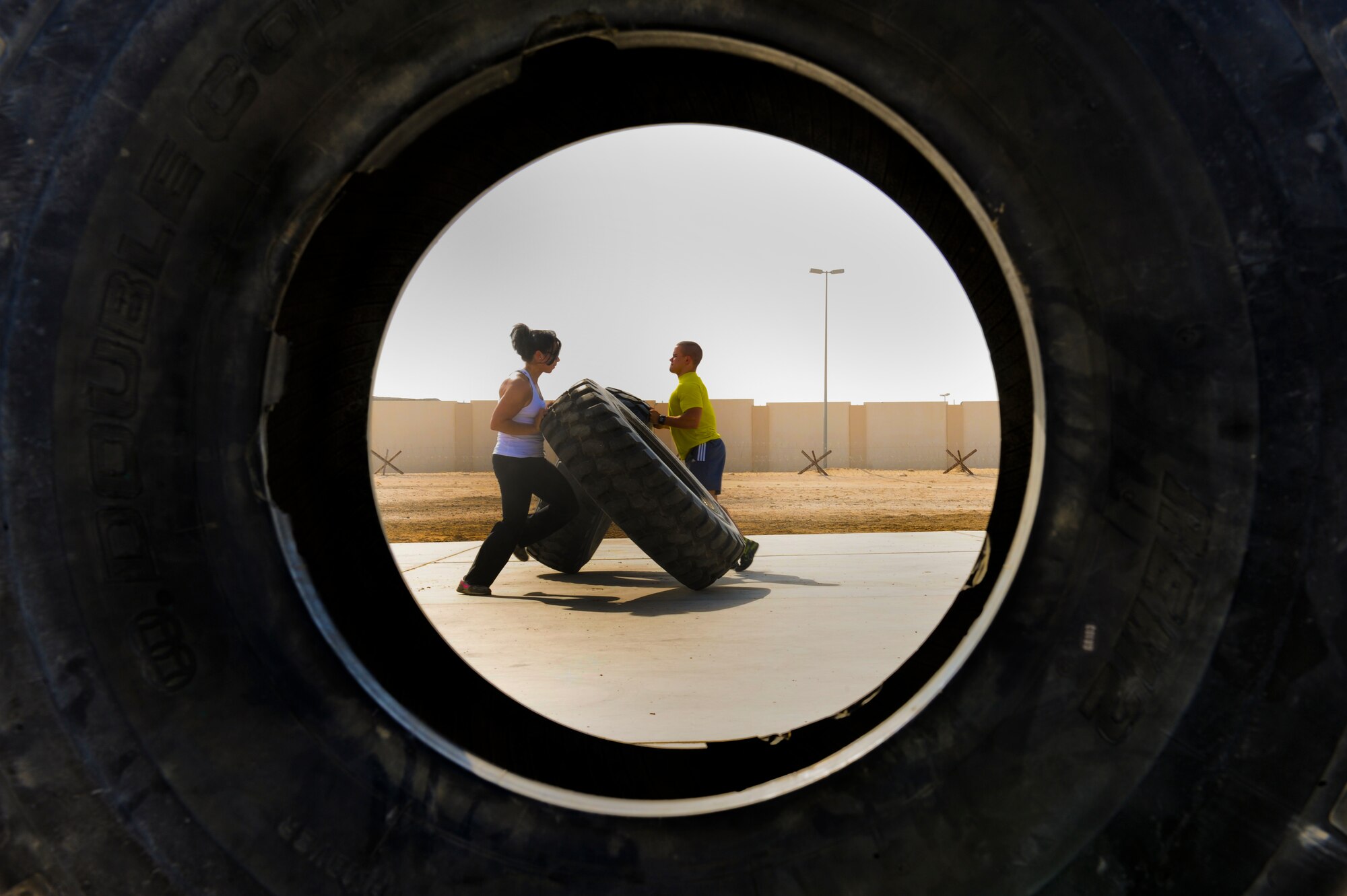 U.S. Air Force Staff Sgt. Vanessa Wyatt and U.S. Air Force Senior Airman Brandon Stout, both from the 380th Expeditionary Civil Engineer Squadron, flip tires at an undisclosed location in Southwest Asia Sept. 11, 2013. Both Wyatt and Stout placed in the Strongest in the AOR competition, Wyatt placing second in the overall woman's category and Stout winning first place. Wyatt is native to Orange, Calif., and is deployed Nellis Air Force Base, Nev. Stout is a native to Holly, Mich., and deployed from Ellsworth, S.D. (U.S. Air Force photo by Staff Sgt. Joshua J. Garcia)